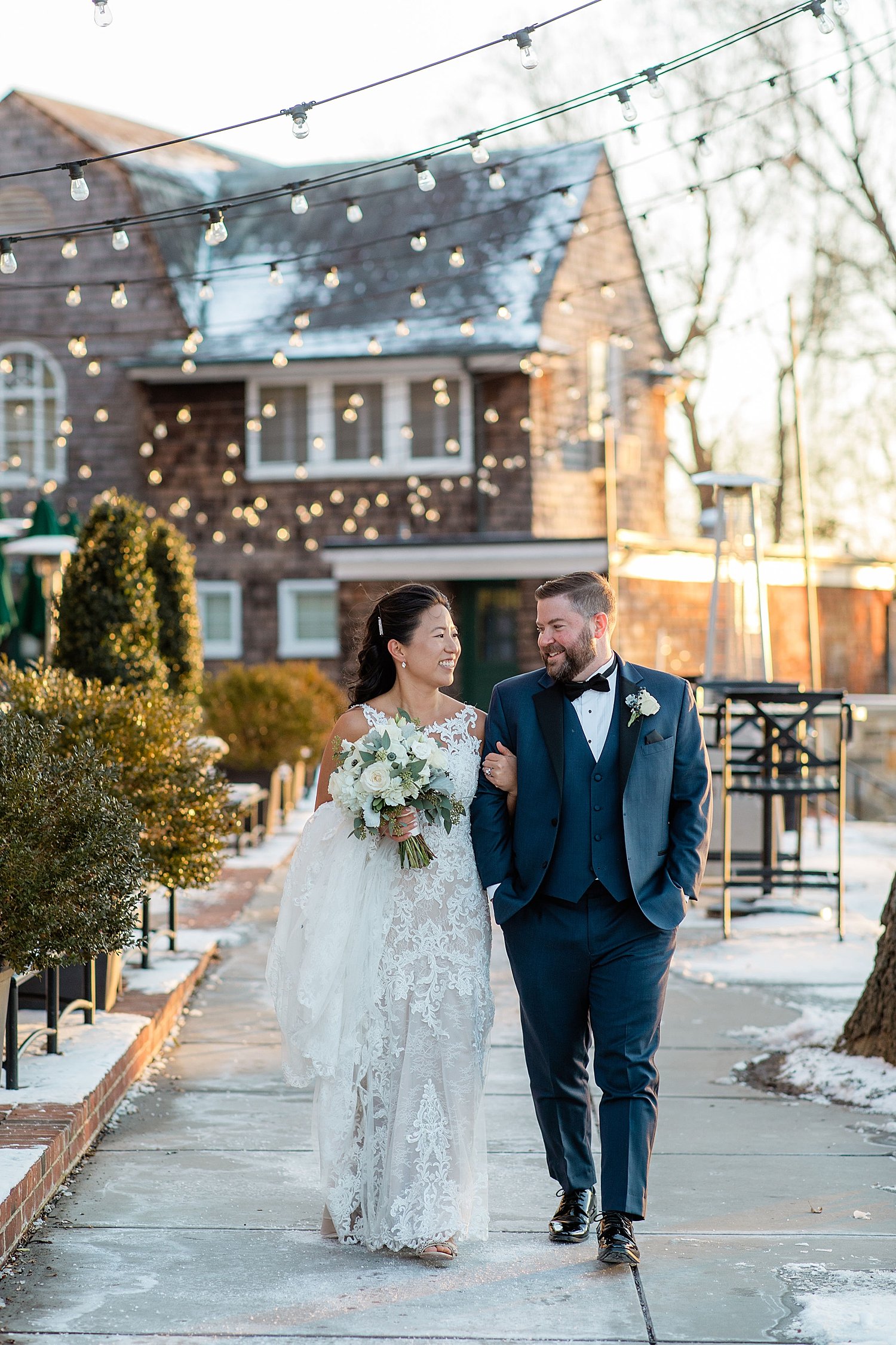 man looks lovingly at his wife under twinkle lights by Maryland wedding photographer