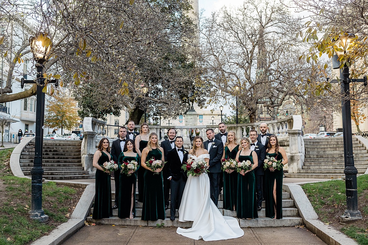 newlyweds stand with their bridal party on the steps at The Belvedere