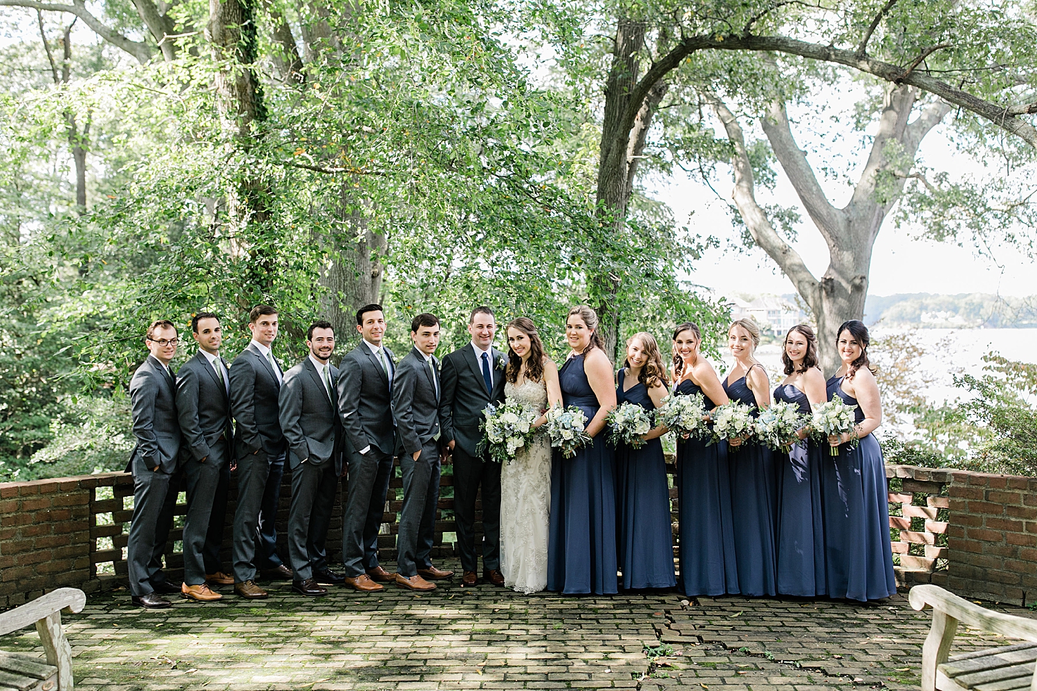 bridal party and groomsmen standing on patio with couple by Jen Harvey Photography