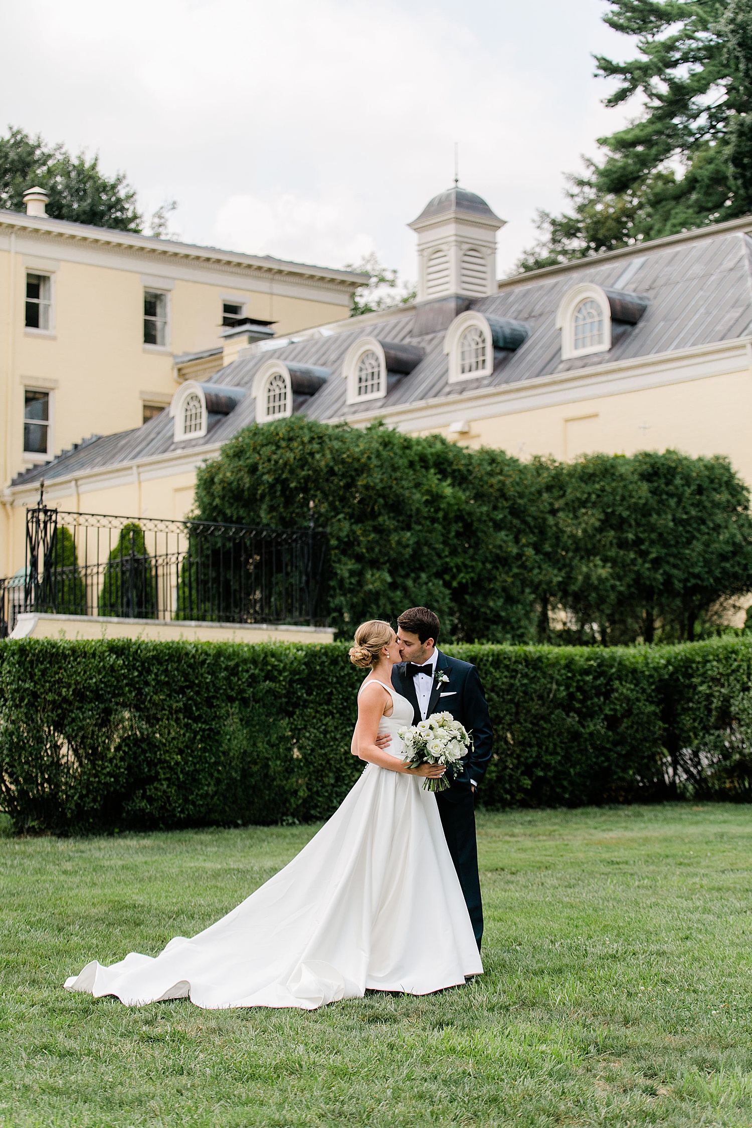 newlyweds kiss on the lawn at The Evergreen Museum 