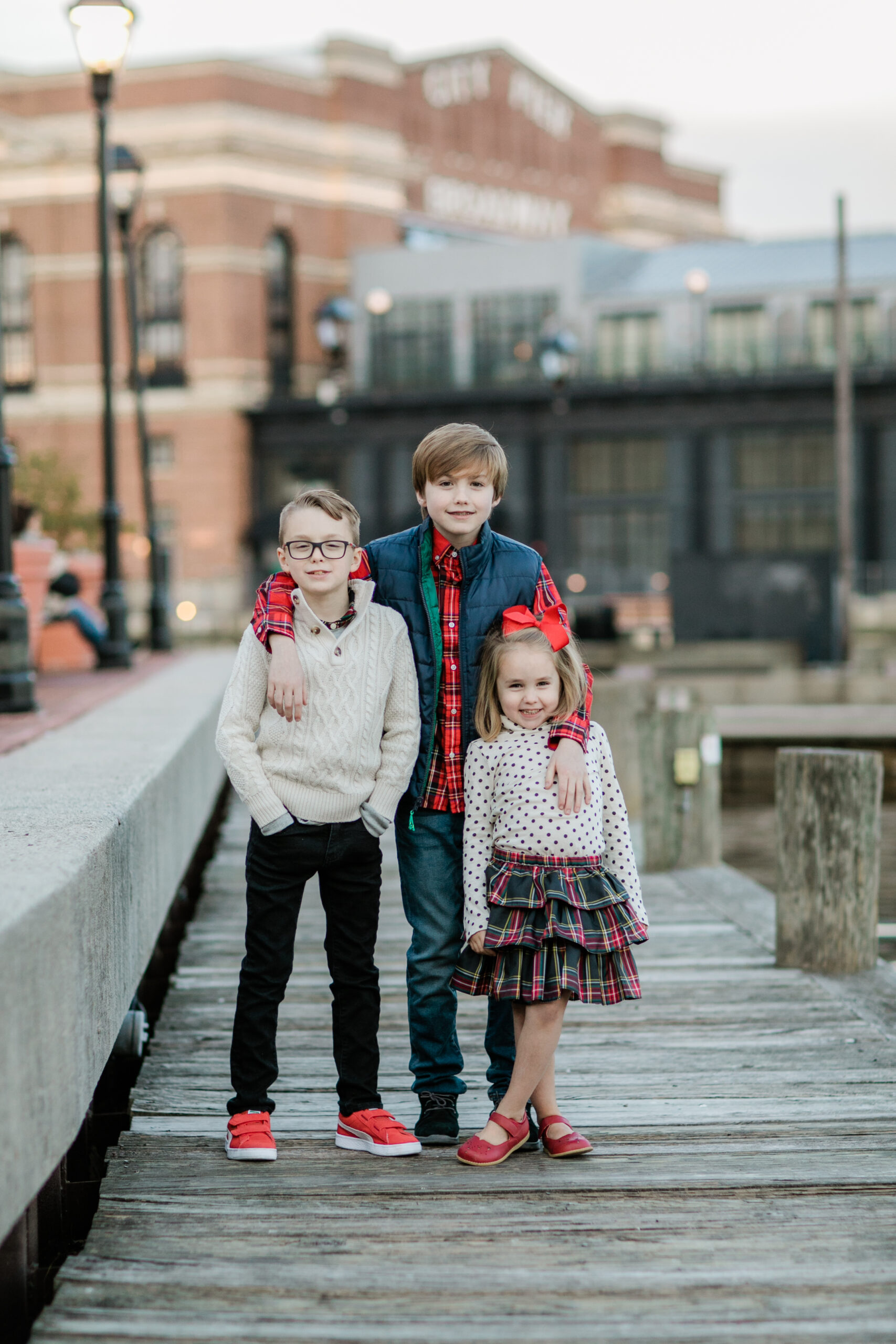 family outfits ideas with coordinated red, cream, and plaid outfits for kids on a Baltimore waterfront dock