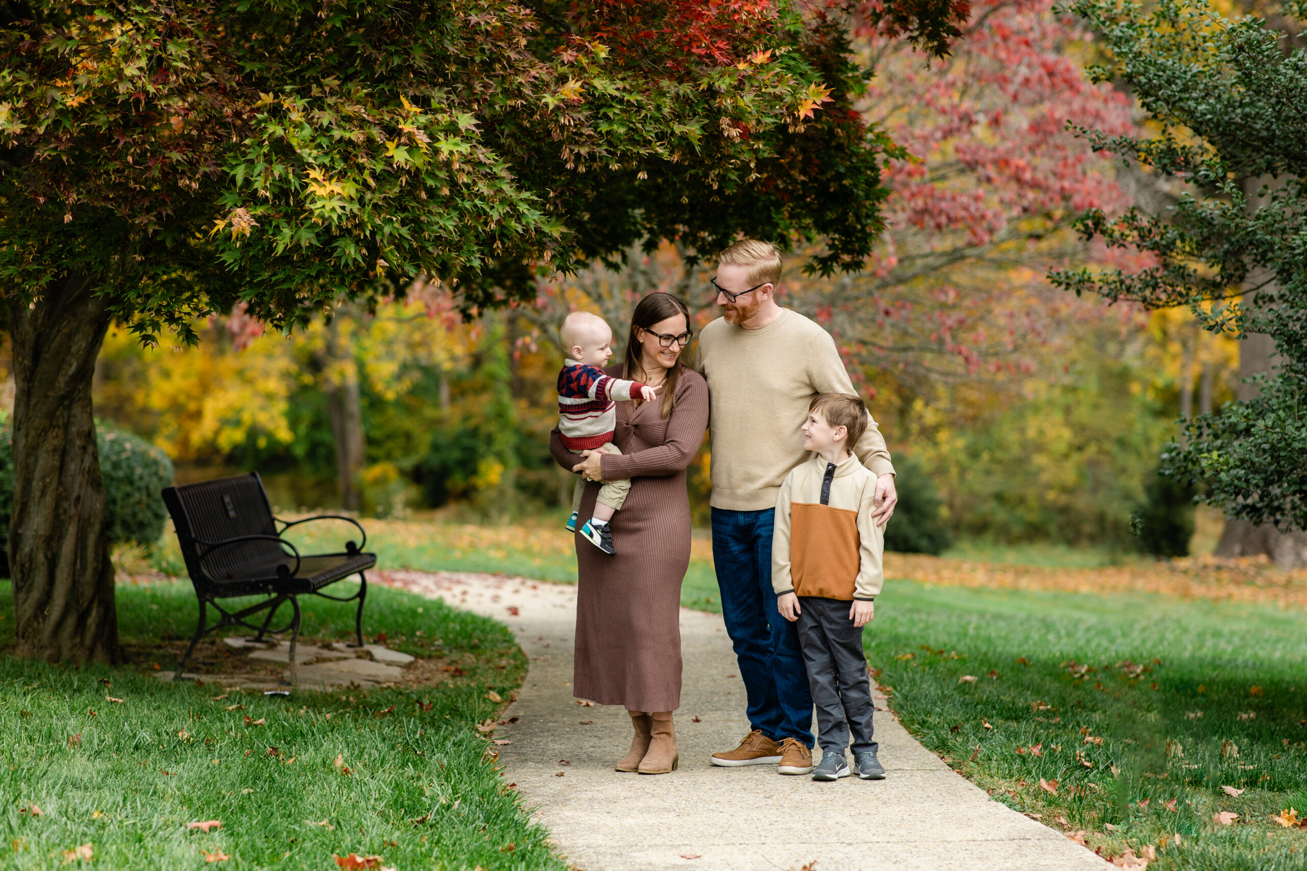 siblings sitting together during a fall family photoshoot with cozy sweaters and neutral outfits