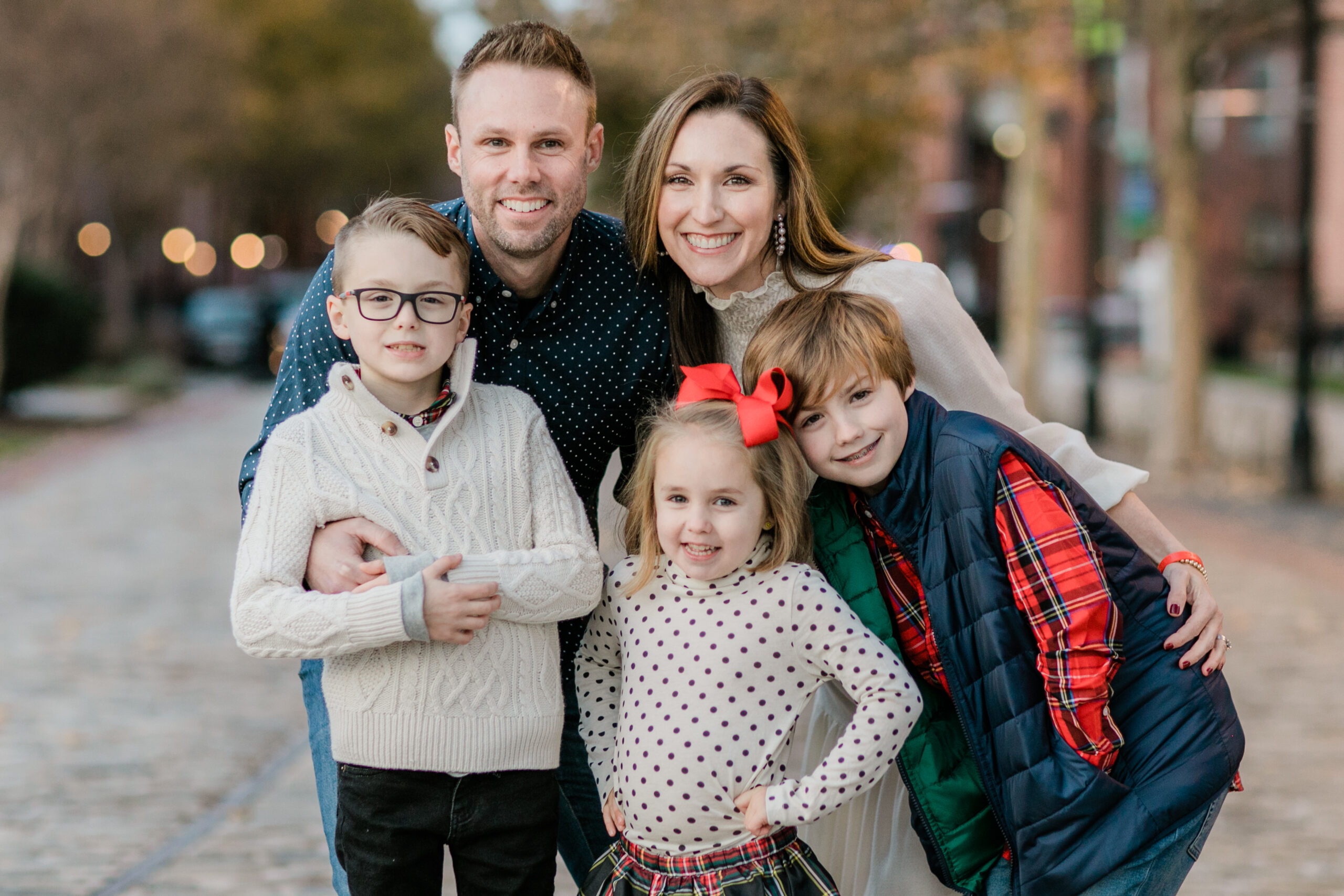 Family winter outfits ideas with coordinated red, cream, and plaid outfits