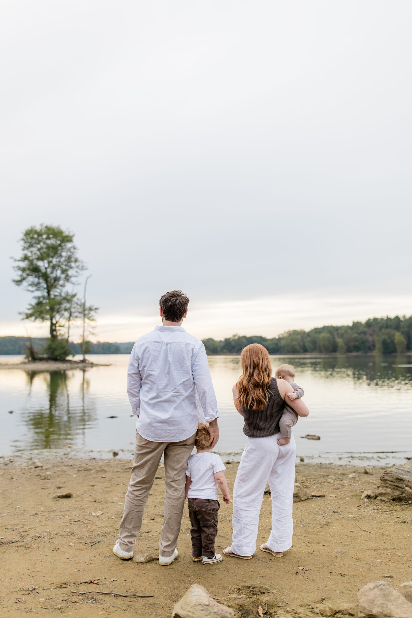 family walking together along a lakeshore during a natural lifestyle family photography session