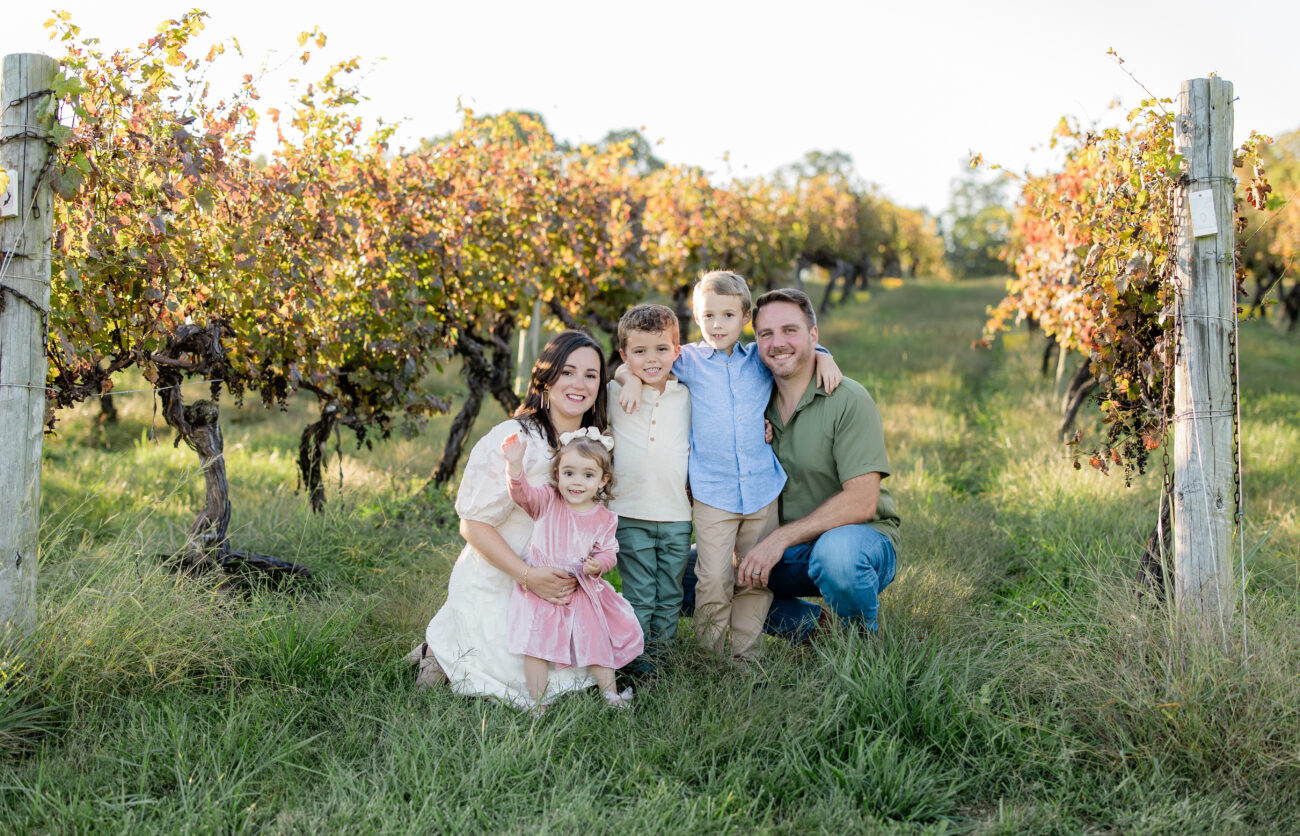 family standing by the lake with coordinated neutral outfits and soft earthy tones