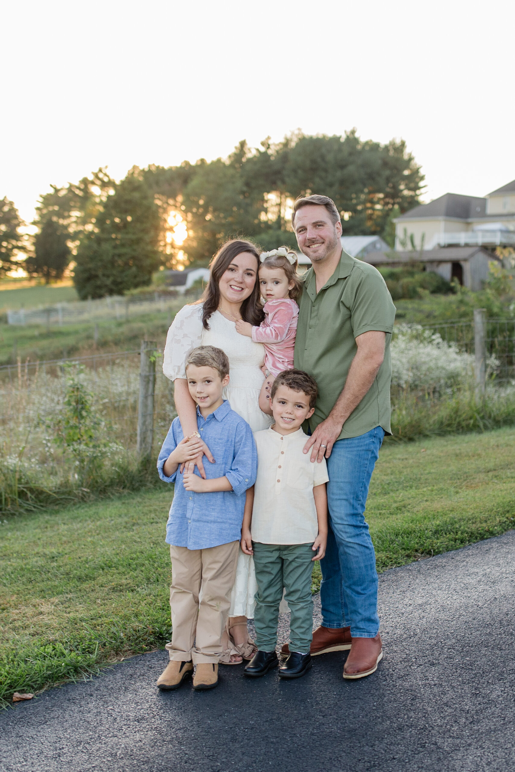 Family wearing cream, olive green, light blue, and beige colors for their photoshoot