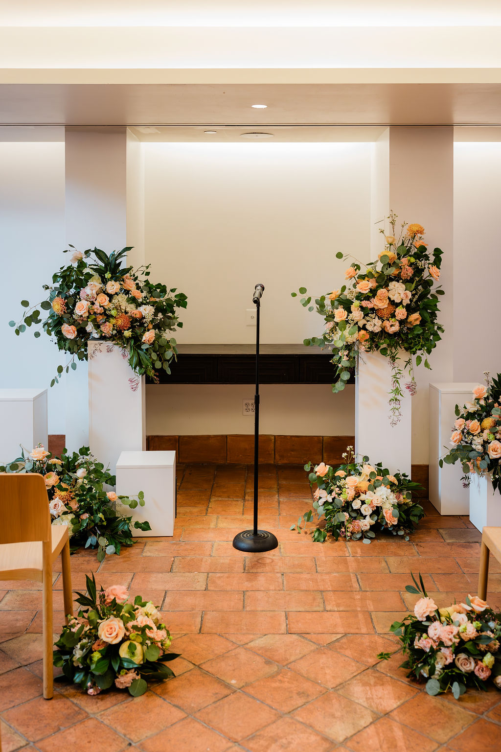 floral setup of tones of peach, white, and yellow at a wedding altar