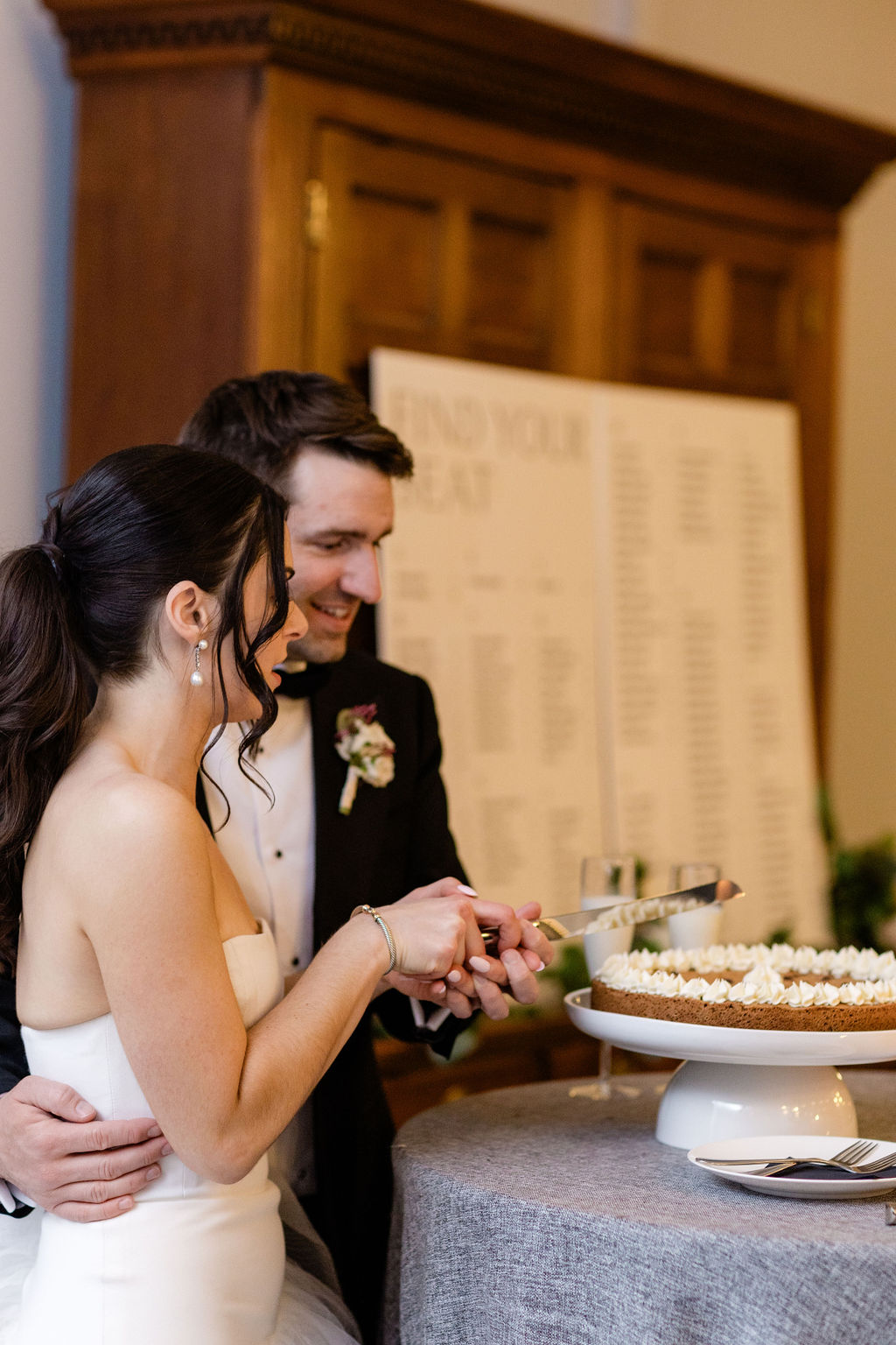 bride and groom cutting wedding cake during an intimate reception moment