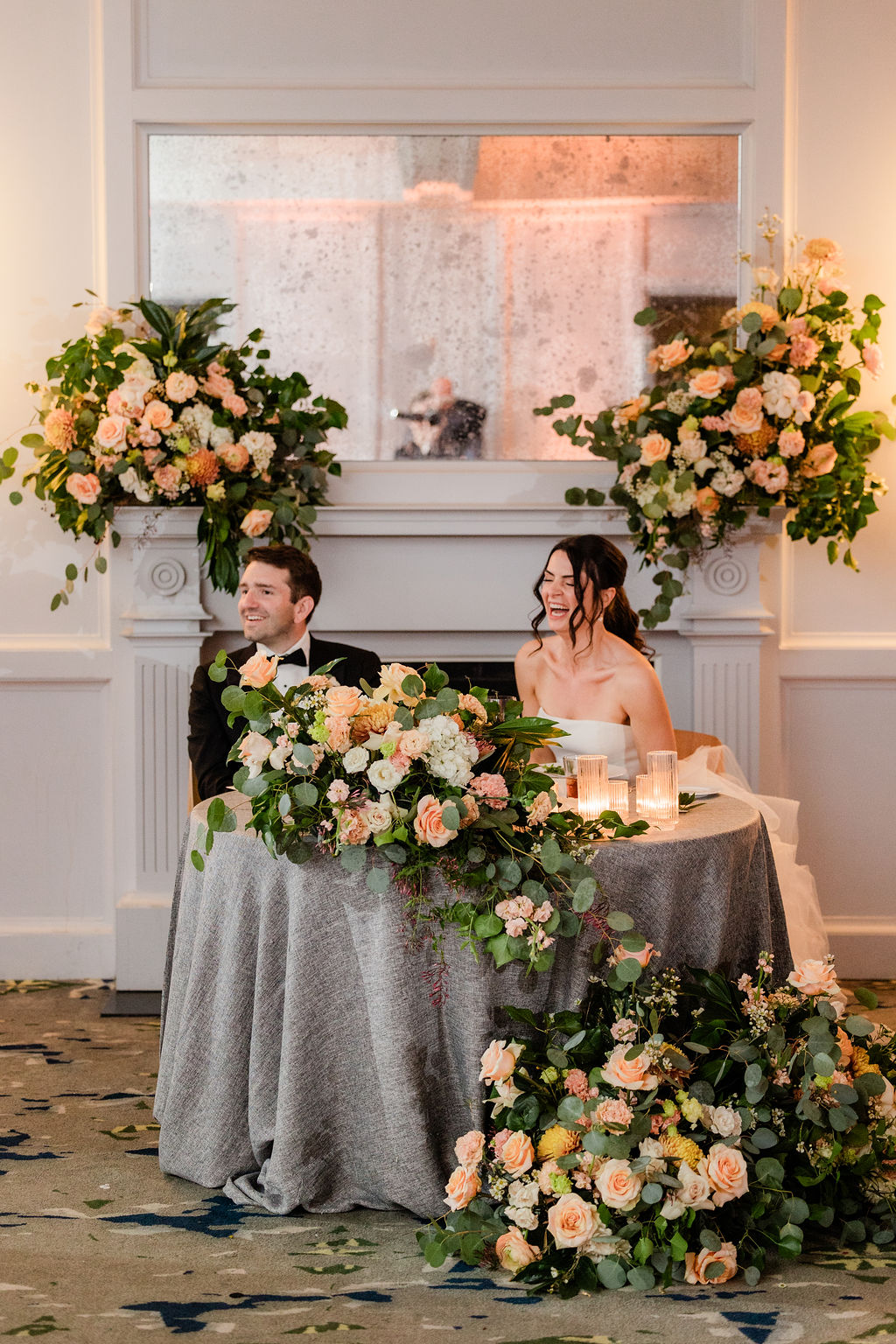 romantic sweetheart table with peach and ivory floral arrangements at a classic wedding reception