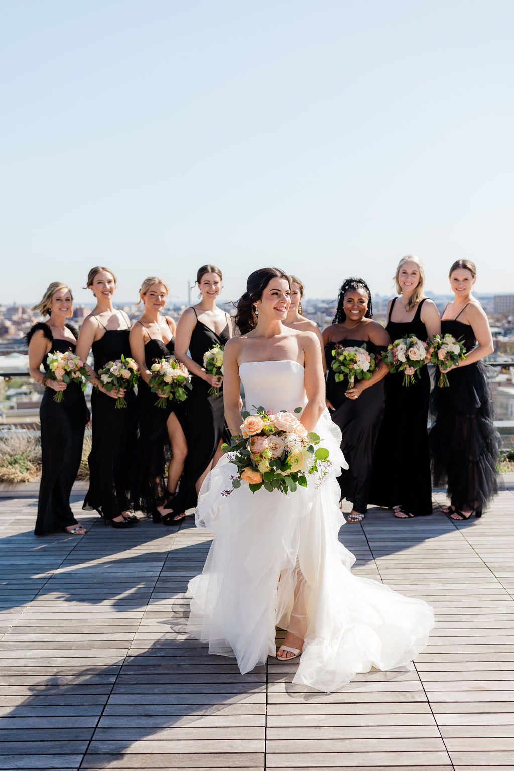 A bride standing in front of her bridesmaids on a rooftop of a dc wedding venue 