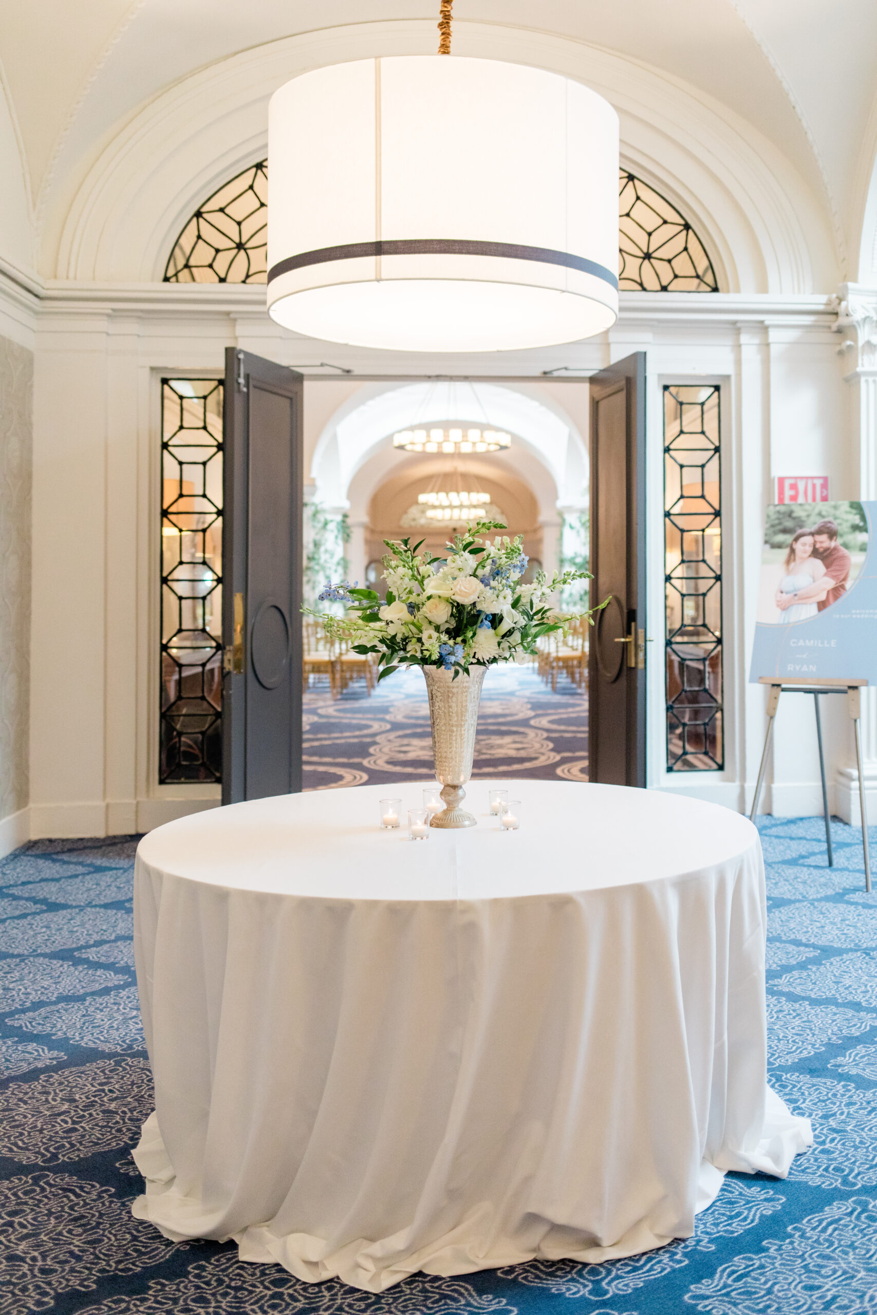 hotel monaco washington ceremony space with floral welcome table and arched entryway