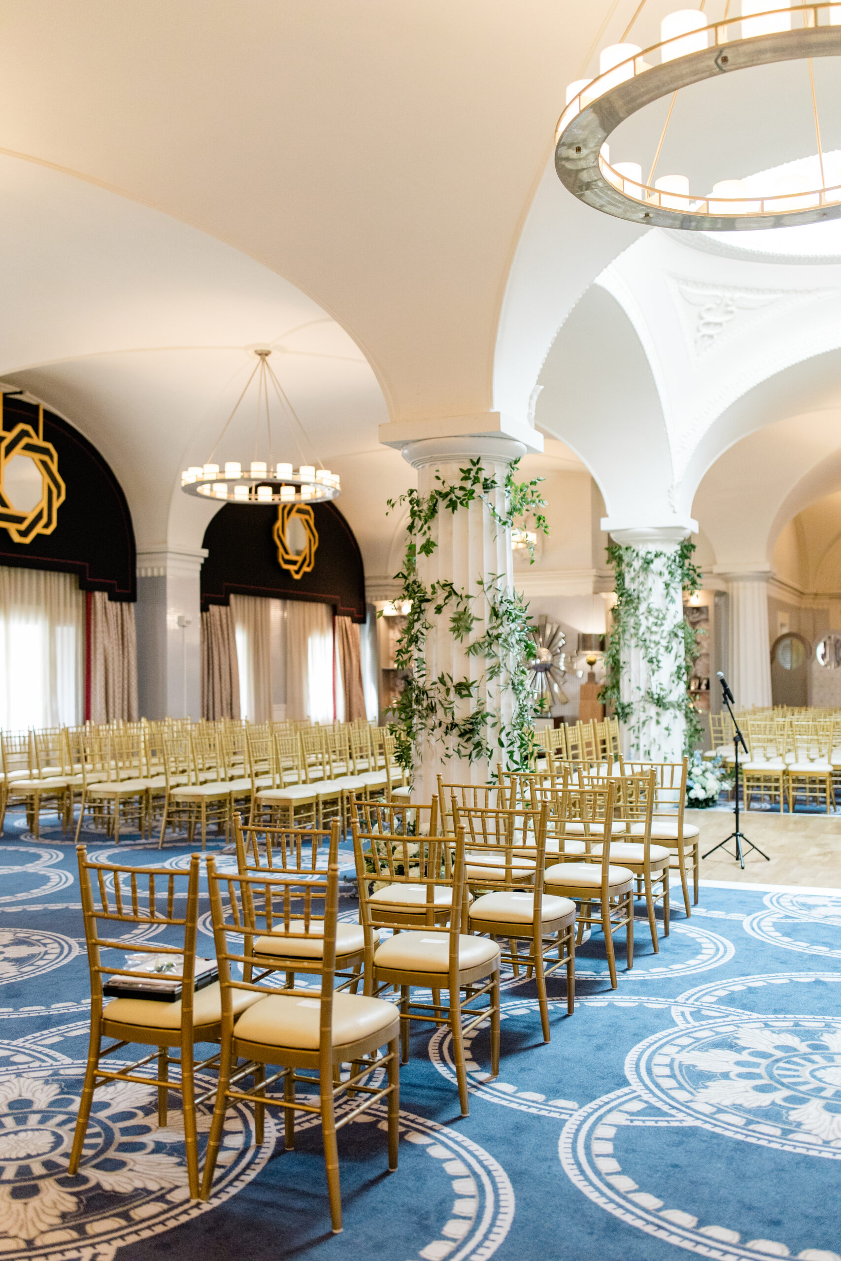 elegant wedding ceremony space with gold chairs and column details