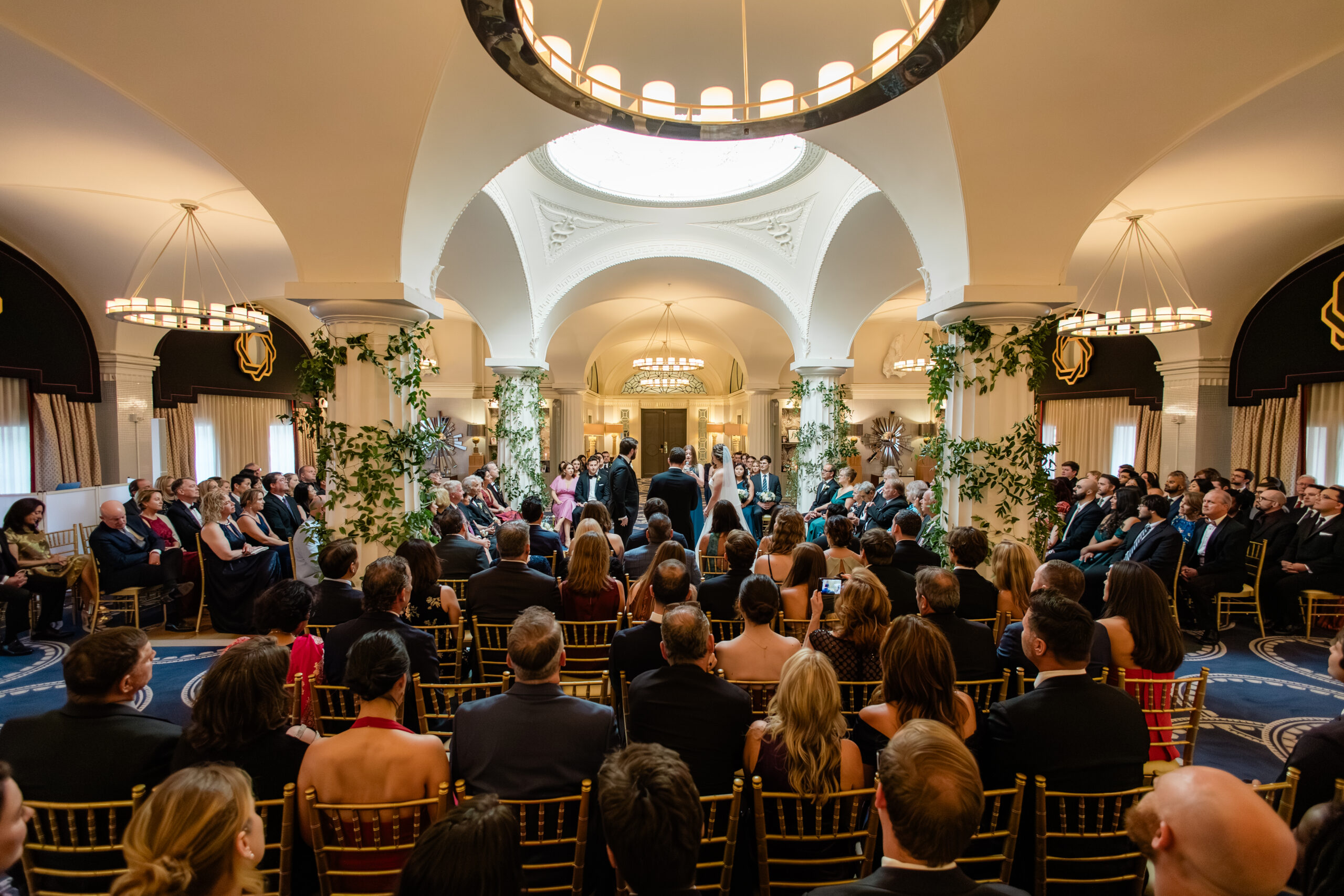 washington ceremony space wide view of wedding ceremony with guests seated under chandeliers and arched ceilings