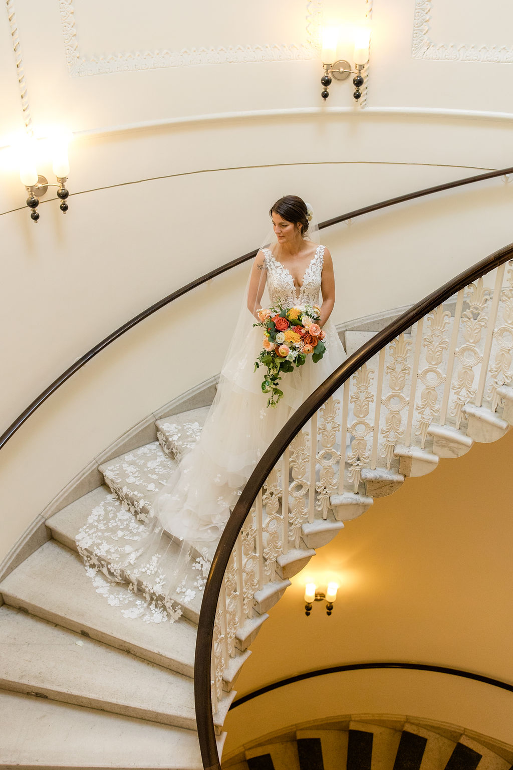 bride walking down grand staircase with bouquet at washington dc wedding venue