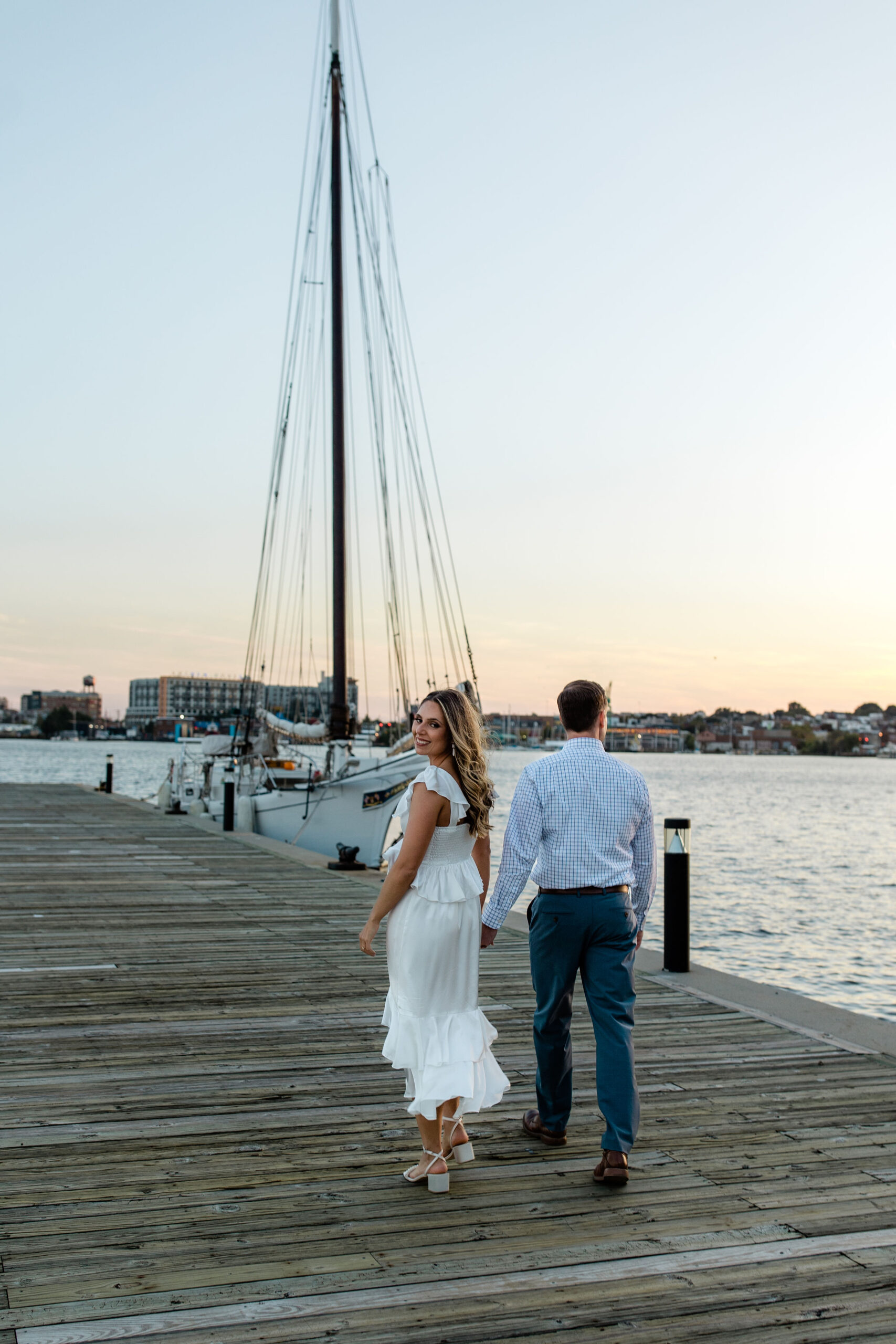 Waterfront engagement photo session at Fells Point marina during golden hour in Baltimore