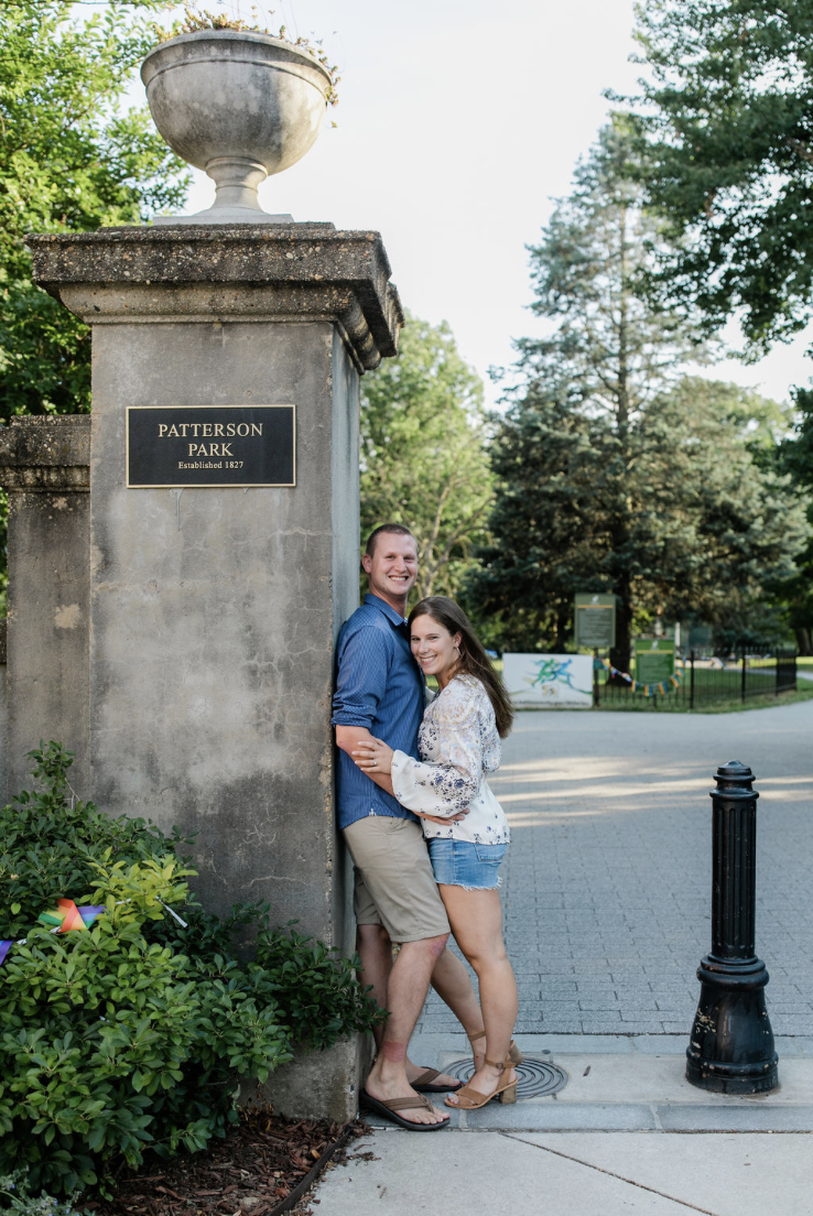 Couple standing near the Patterson Park entrance during an engagement session at one of the best engagement photo locations in Baltimore