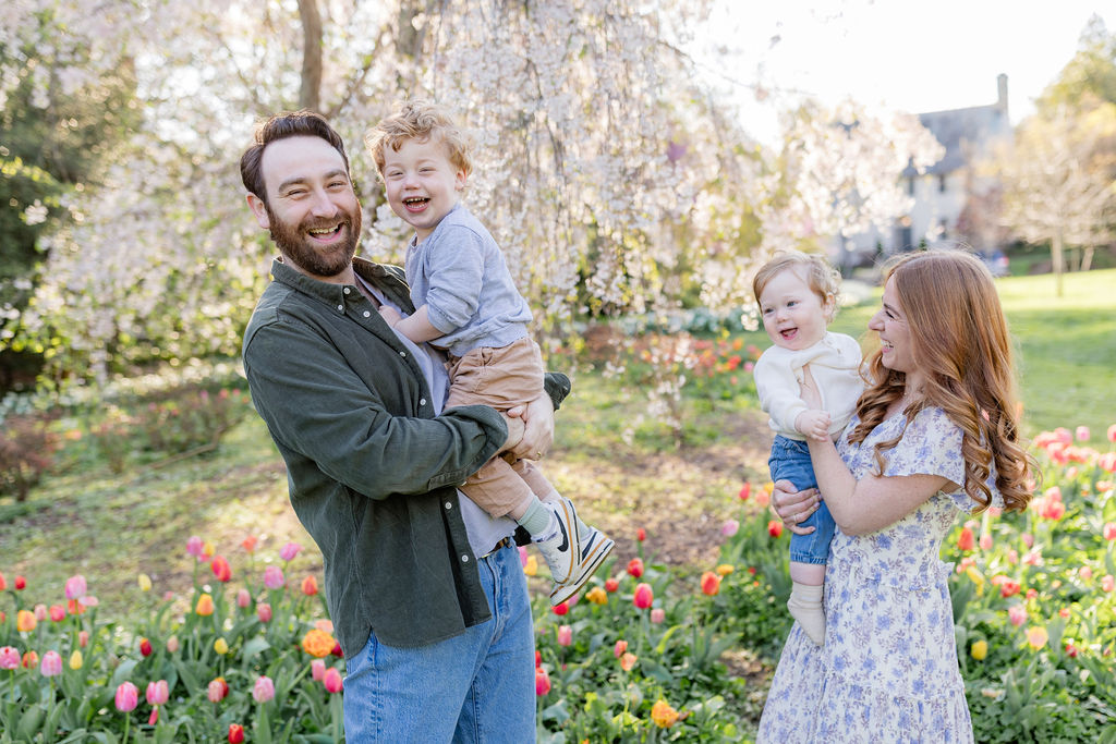 a father and mother holding their children during their spring photoshoot