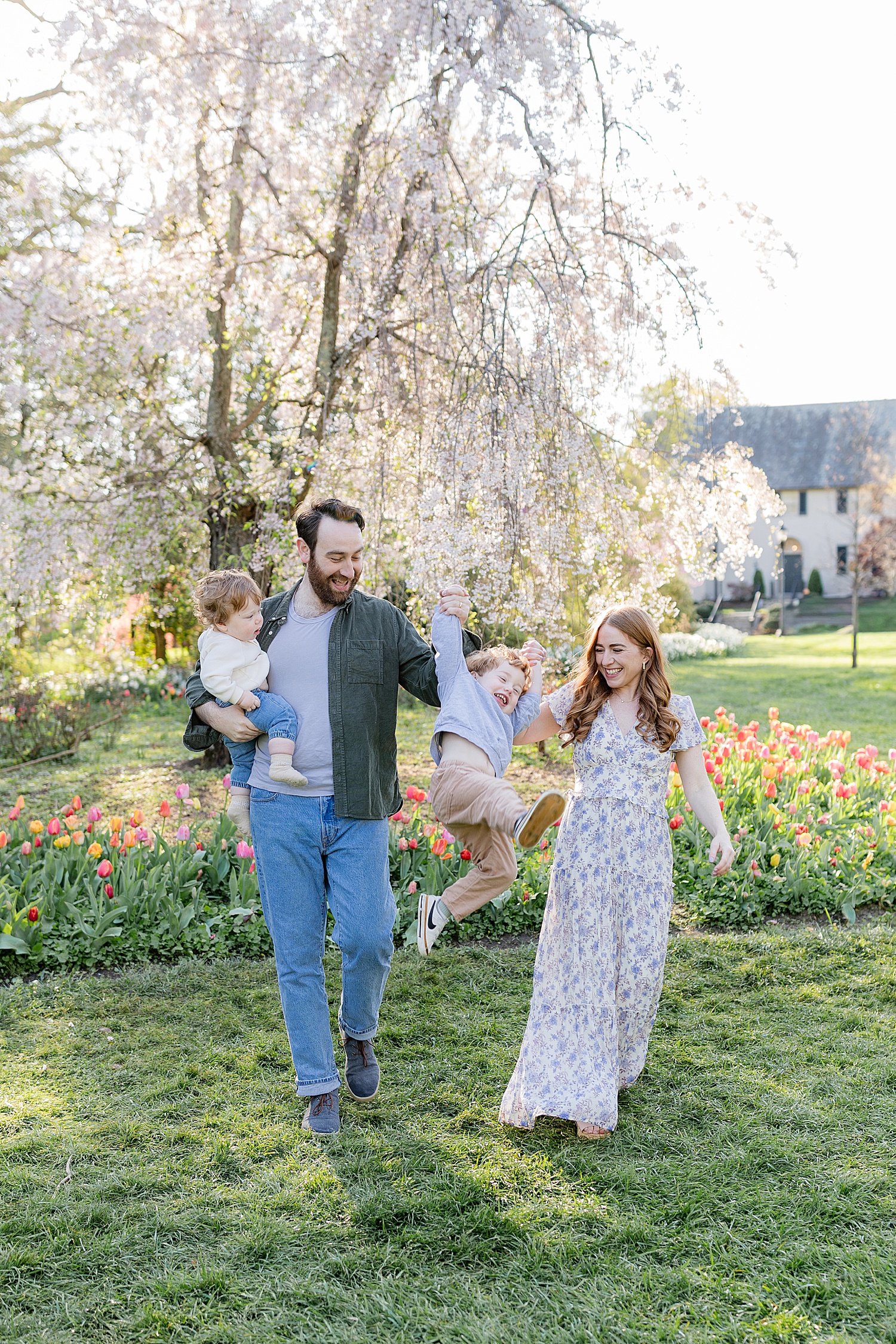 parents swing kiddo in between them by Baltimore family photographer