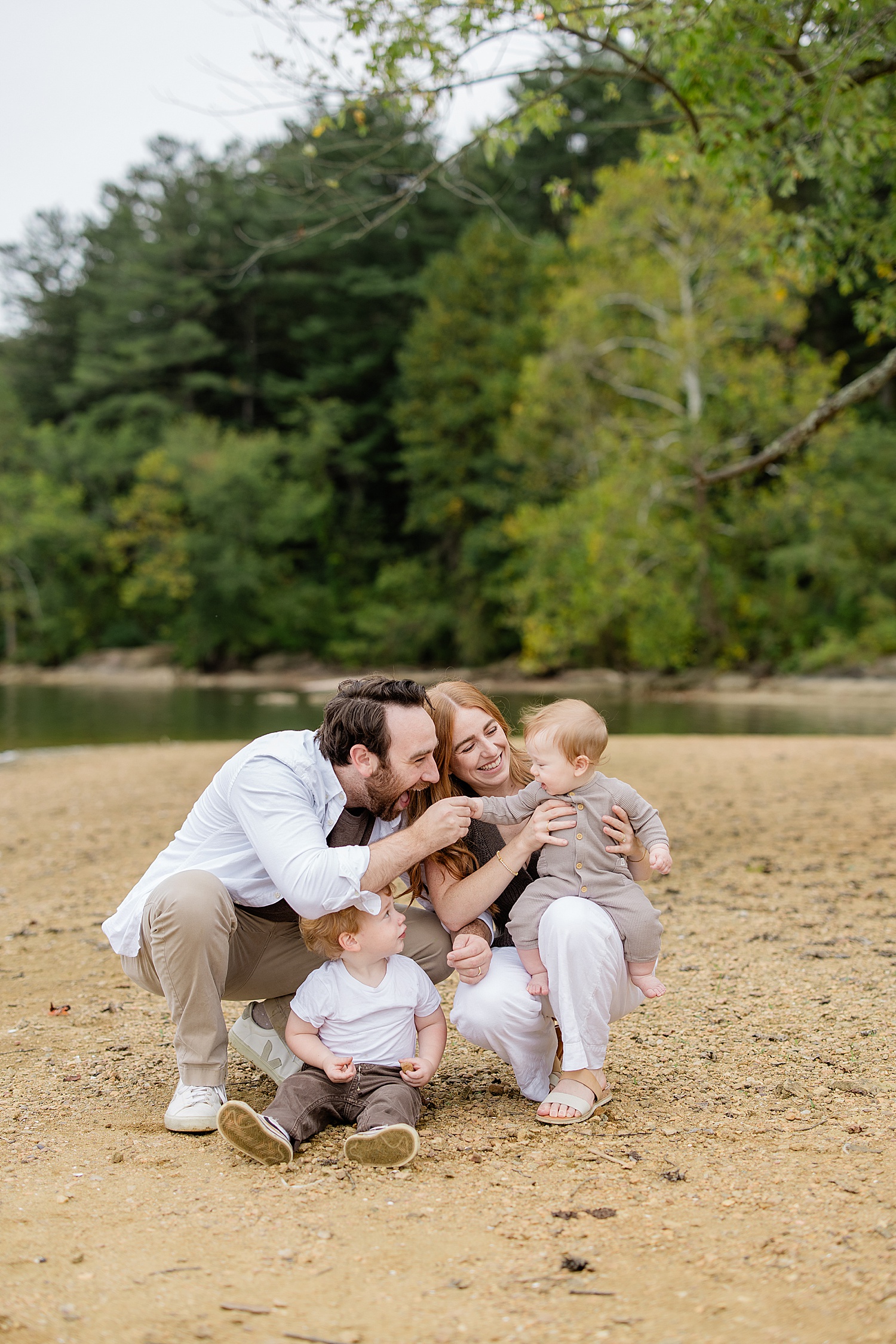 dad and mom play with one year old in sand by Baltimore family photographer