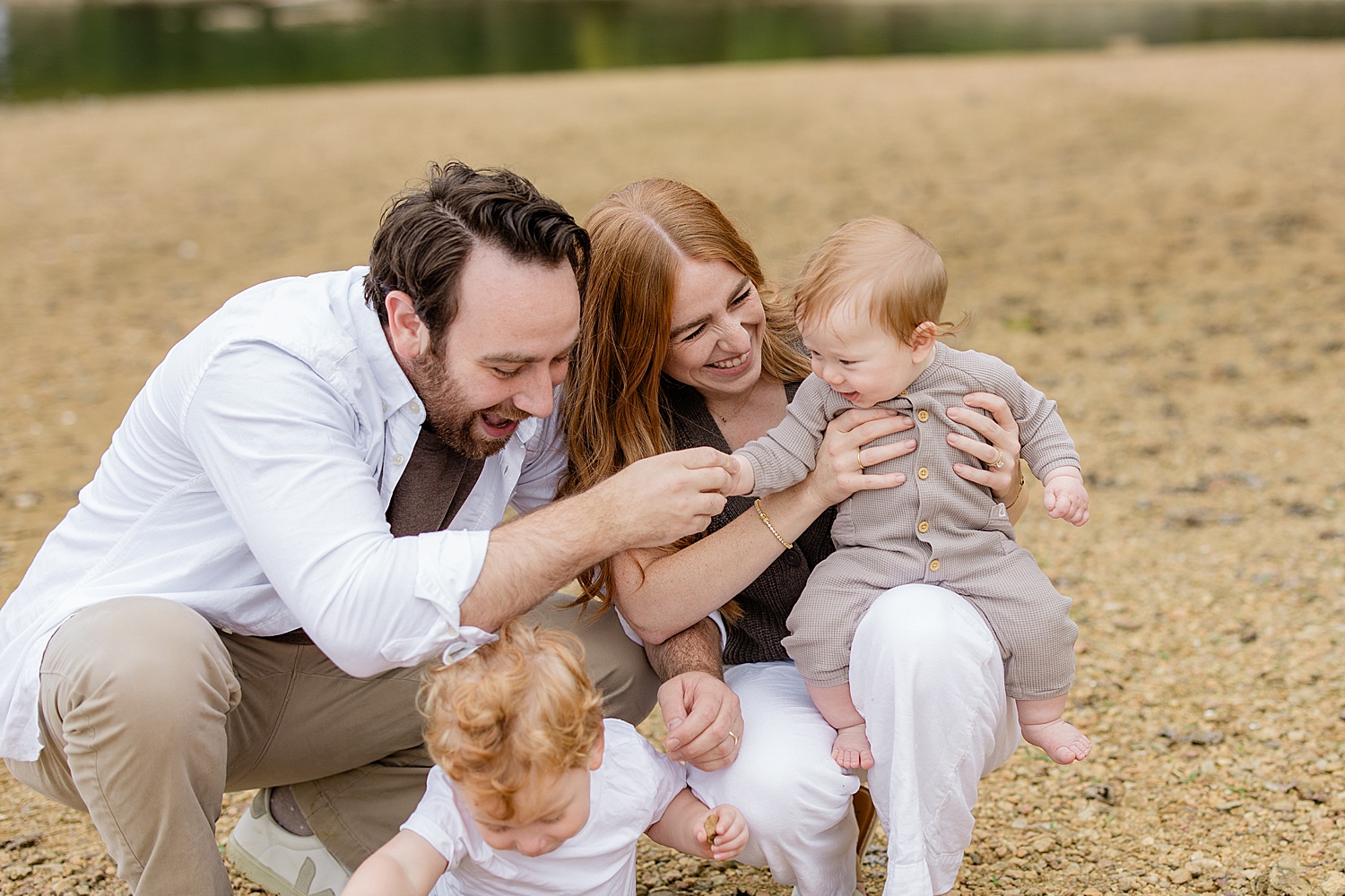 parents smile with their giggling children in Sherwood Garden documenting young families