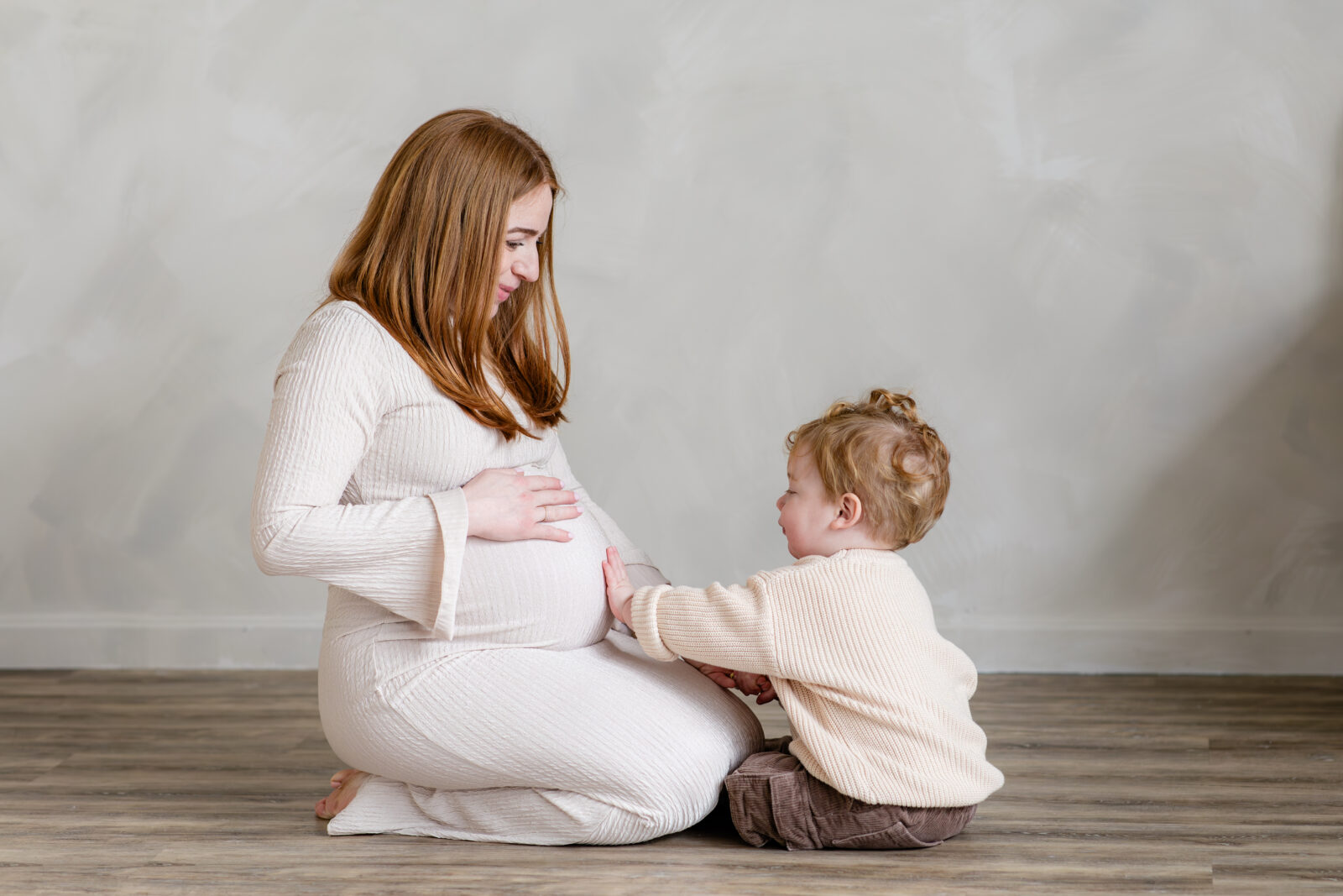 A pregnant mom with her toddler son in a Baltimore photographer's studio.