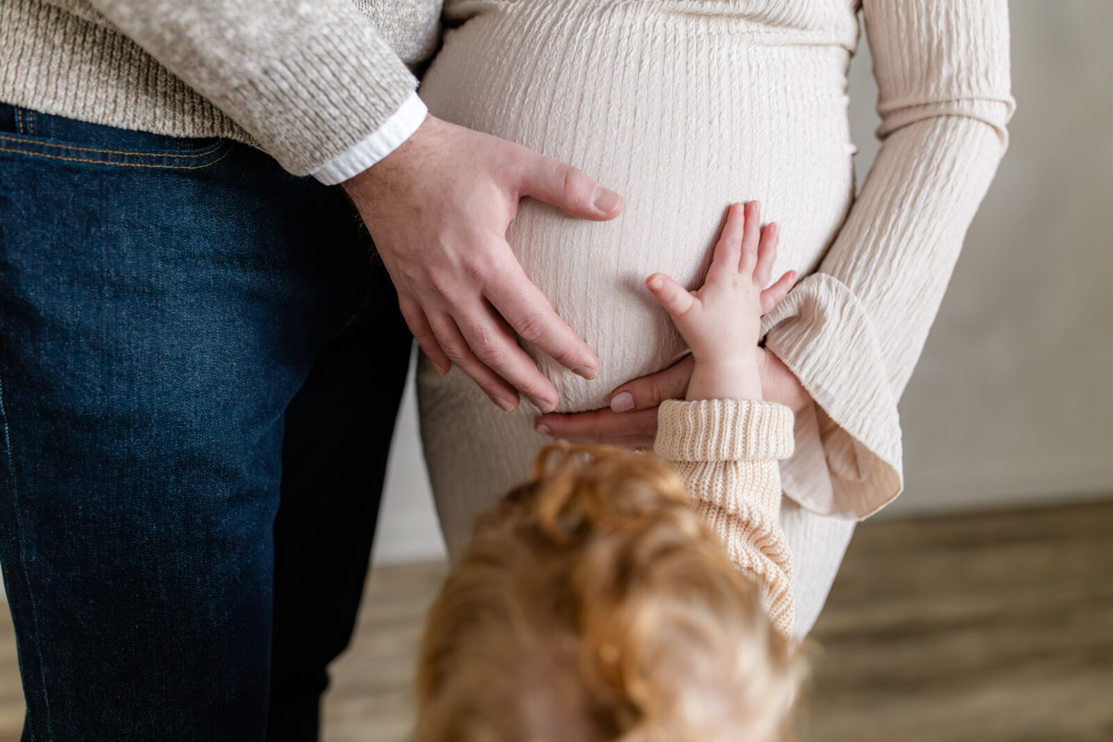 A pregnant mom with her husband and toddler son.