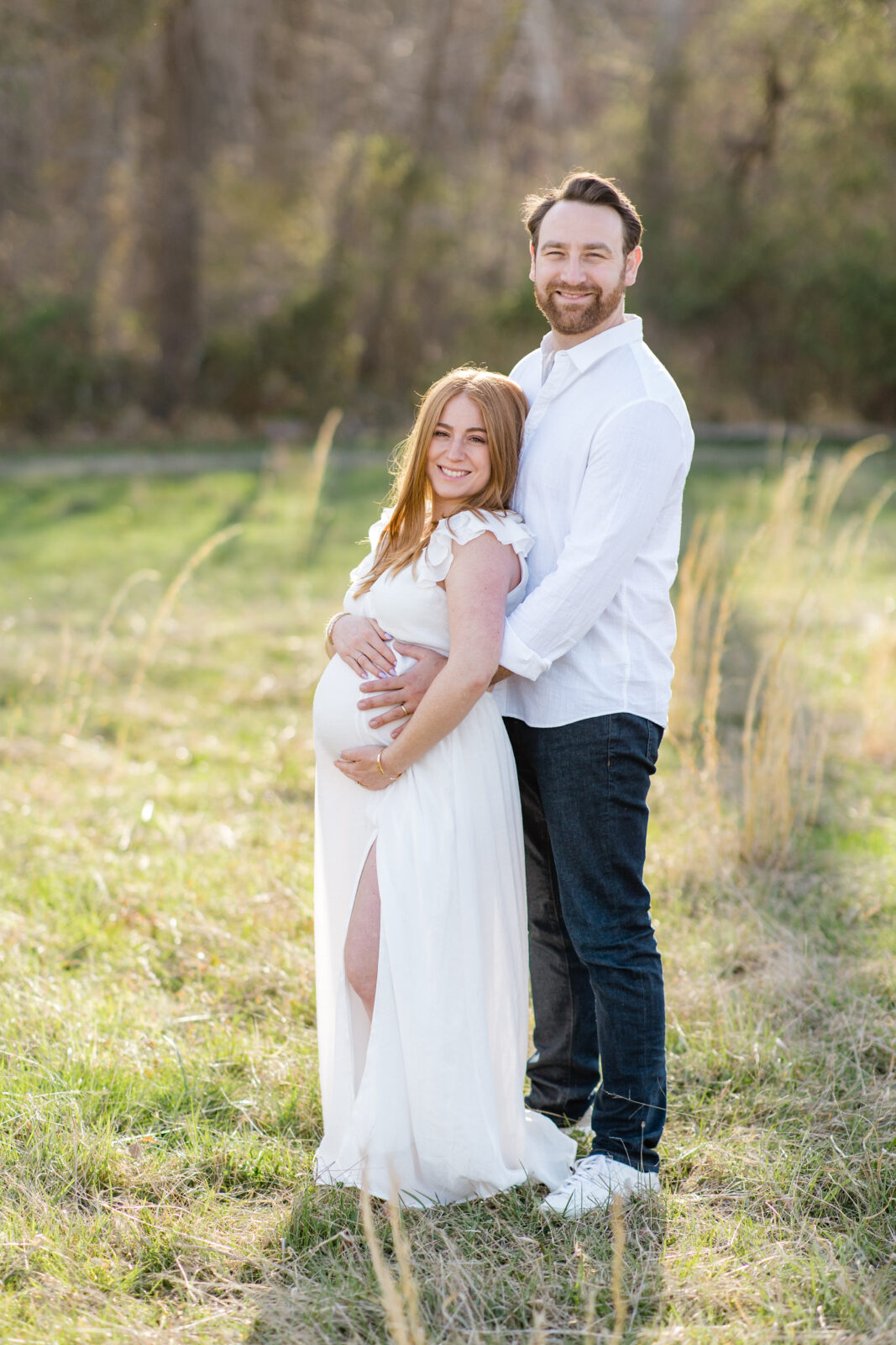 A couple posing for maternity photos by a Balitmore family photographer.