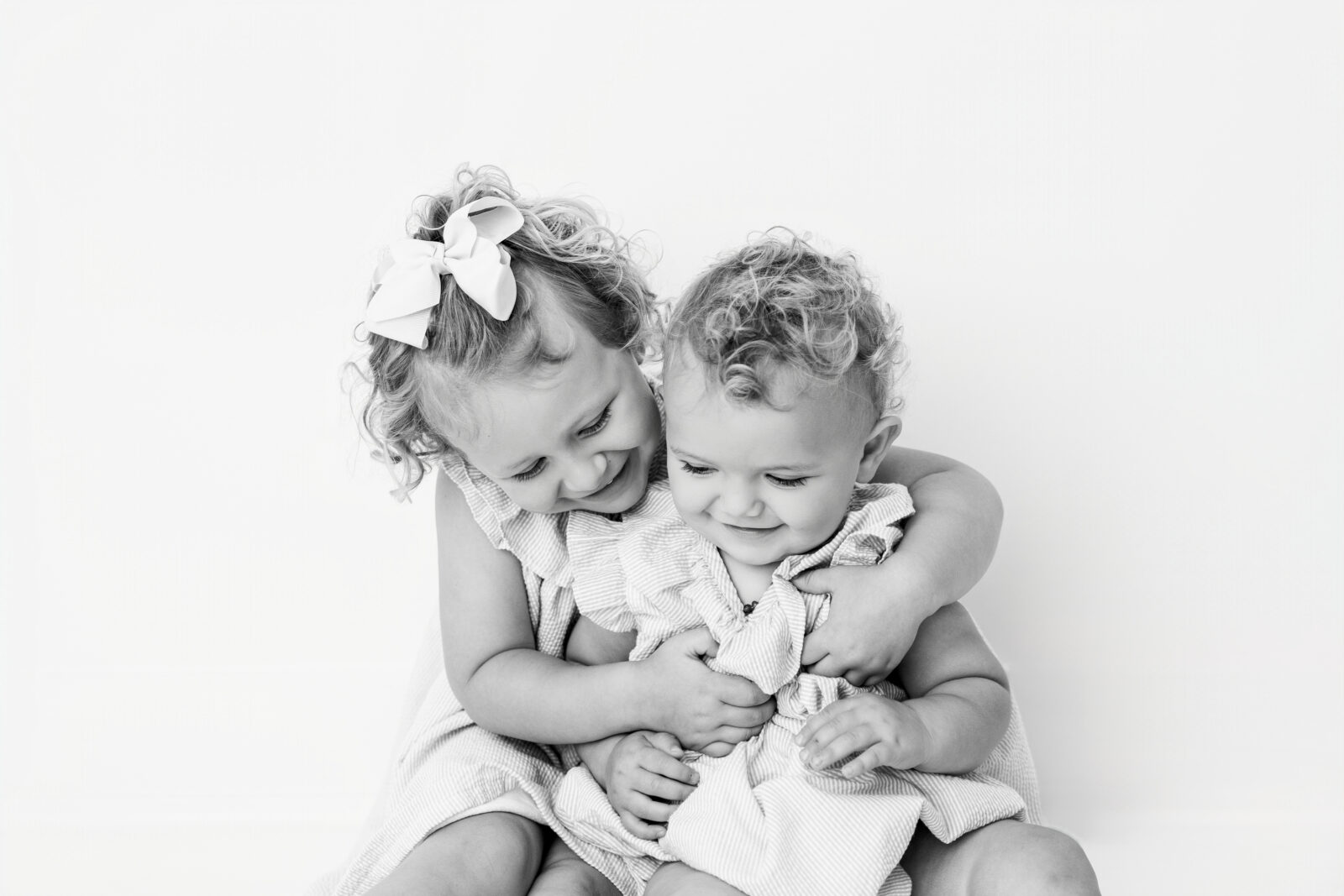 Baltimore children's portrait photographer captures two sisters hugging and smiling
