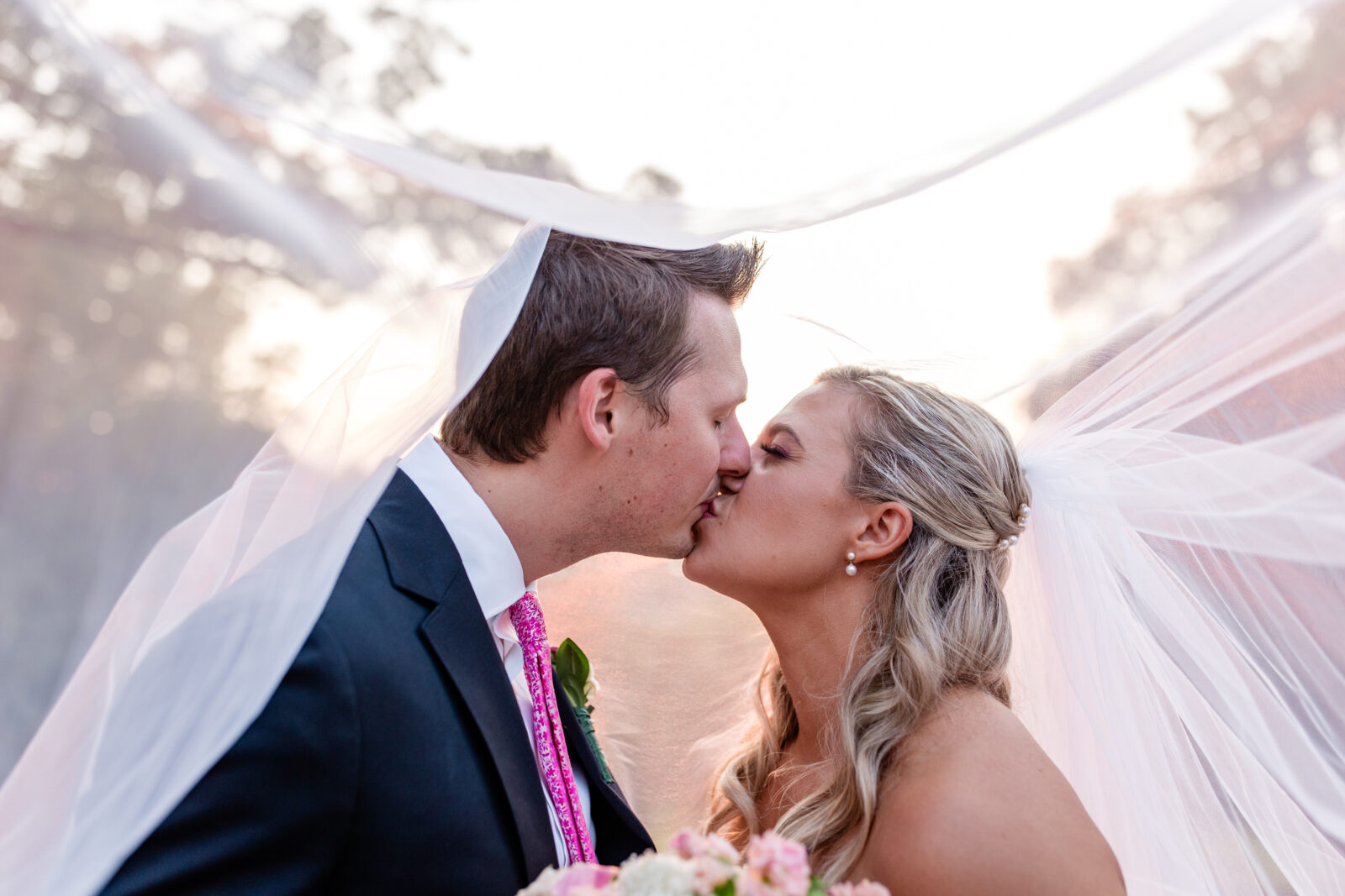 bride and groom share a kiss under her veil in an example of timeless wedding photography