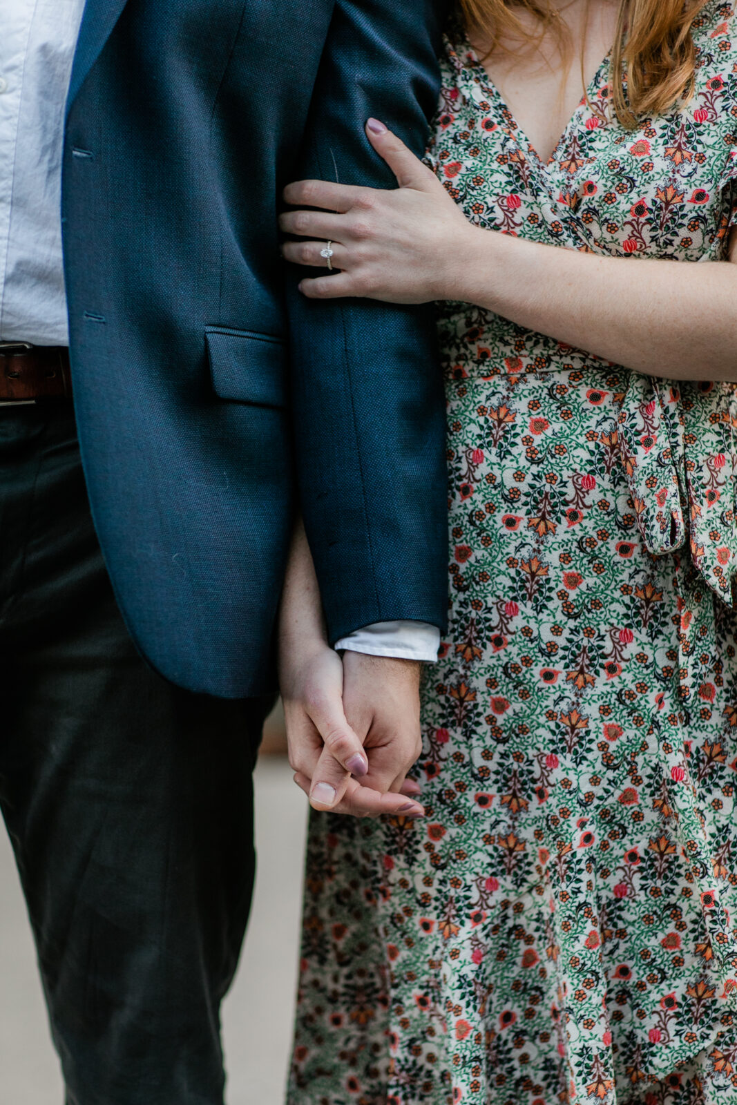 A couple holding hands during their engagement photo session.