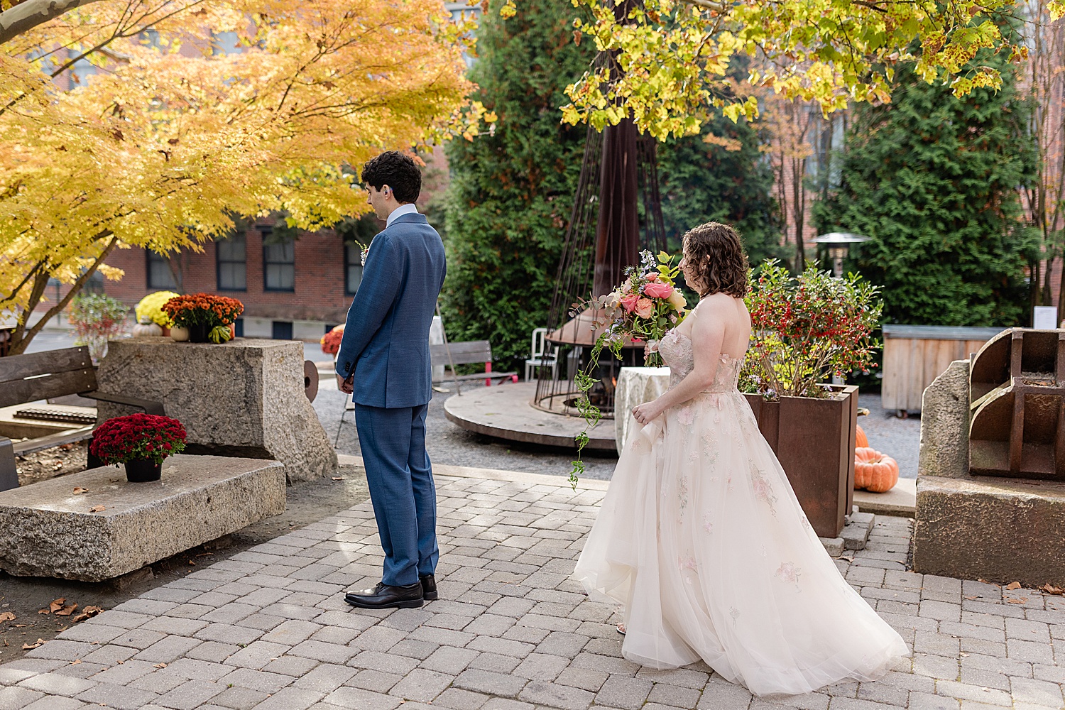 bride approaches man in courtyard for first look at Woodberry Kitchen