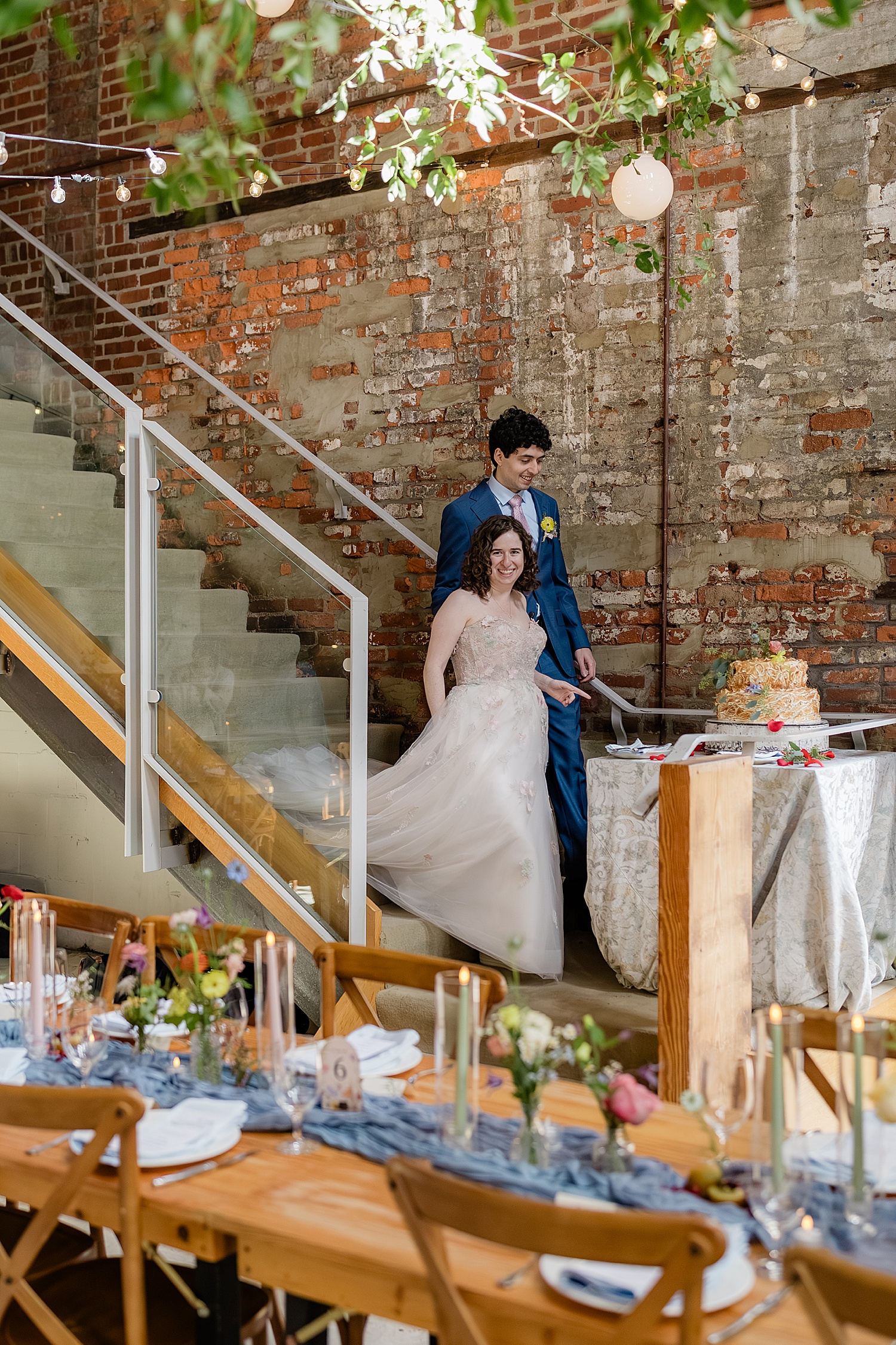 newlyweds walk down steps to see reception space by Jen Harvey Photography