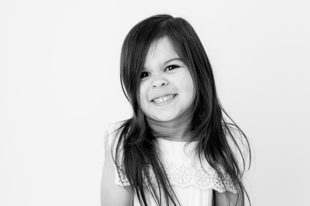 Black and white close-up of child's laughing expression in studio