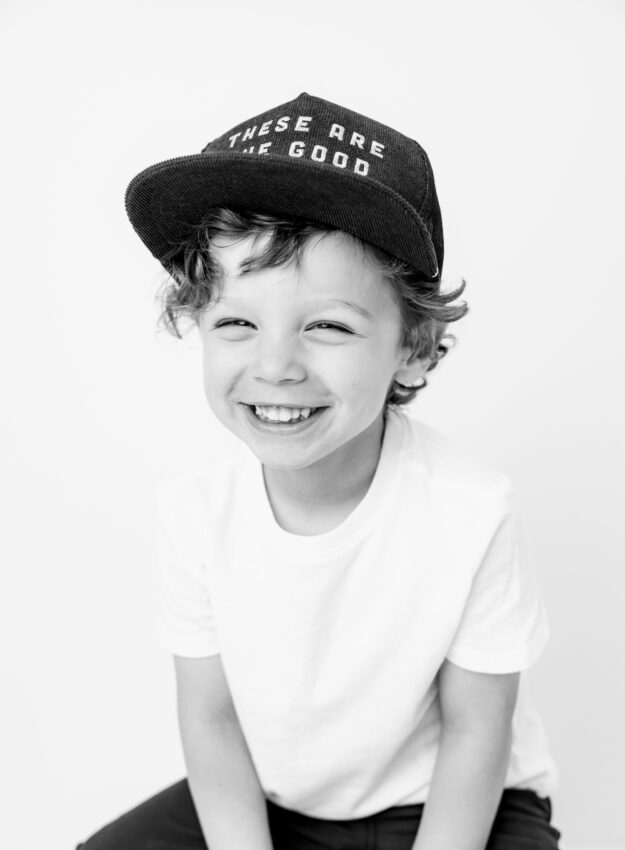 black and white photo of young boy in a hat