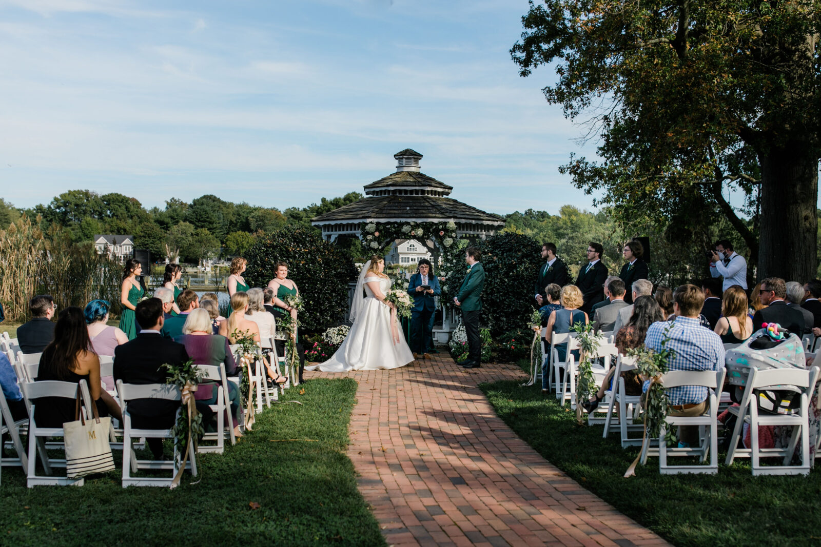 Bride and groom sharing vows at their Kent Island Resort wedding ceremony gazebo while friends and family watch