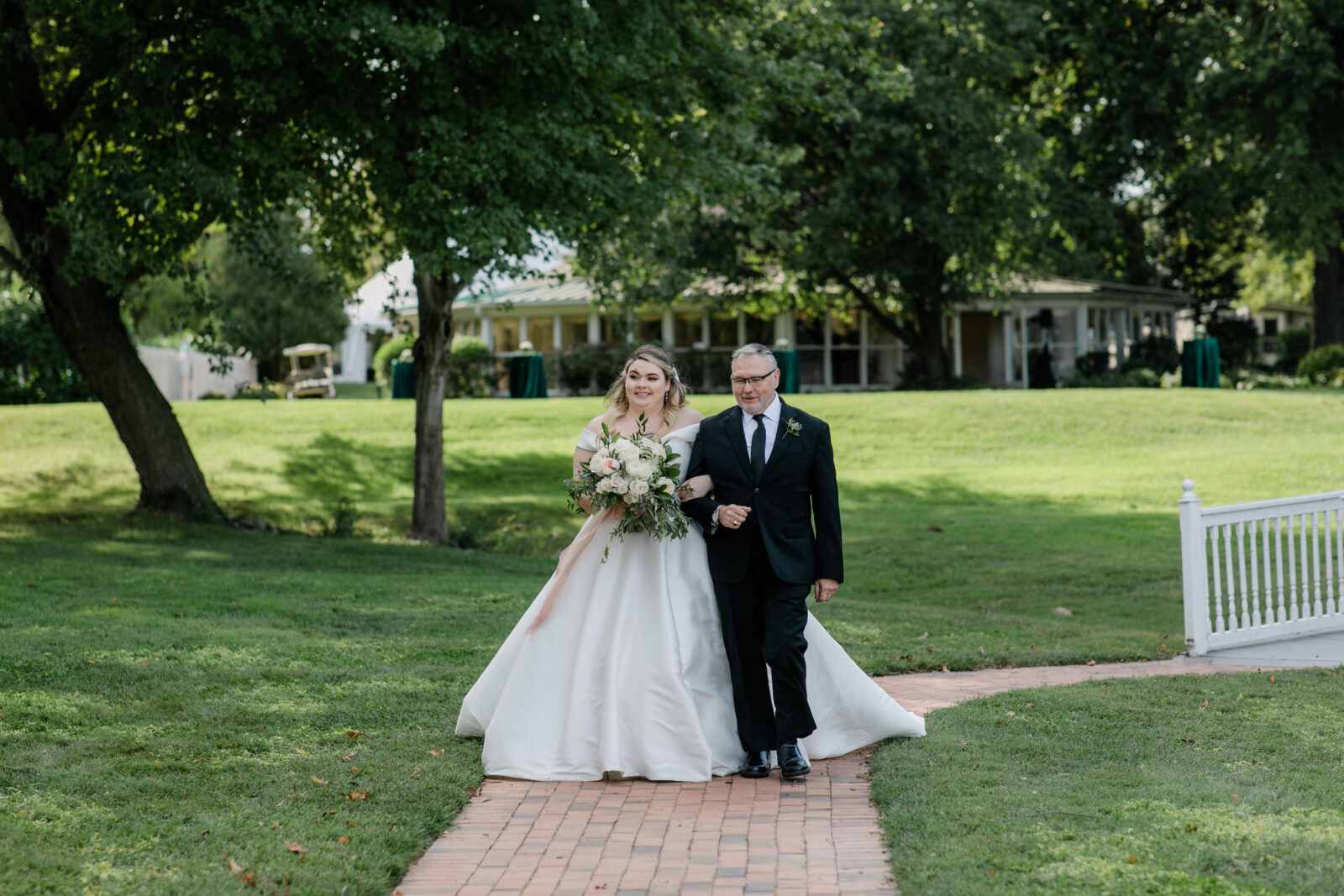 Father walking bride down a brick path to the gazebo at Kent Island Resort