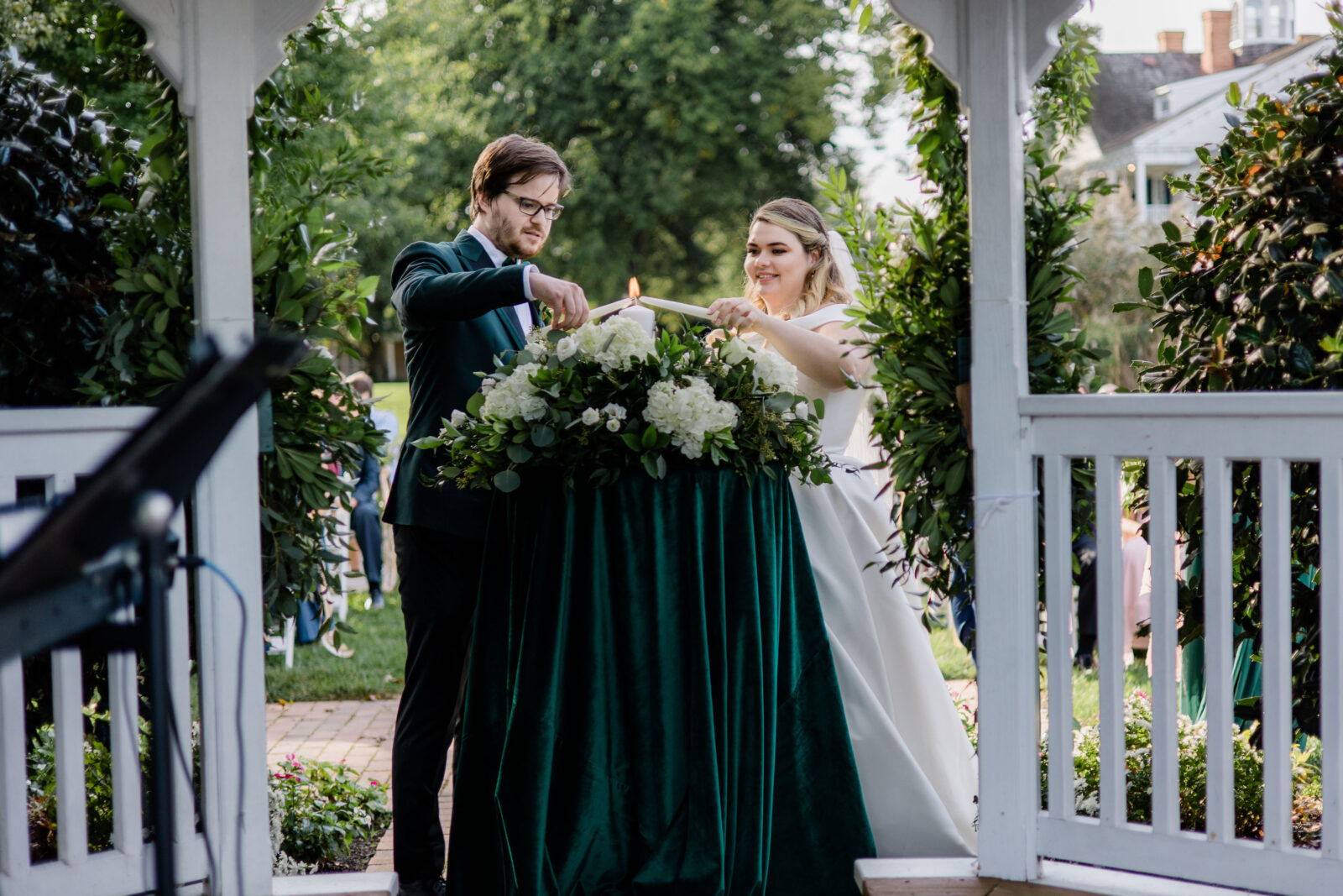 Bride and groom lighting unity candle at their Kent Island Resort wedding ceremony gazebo