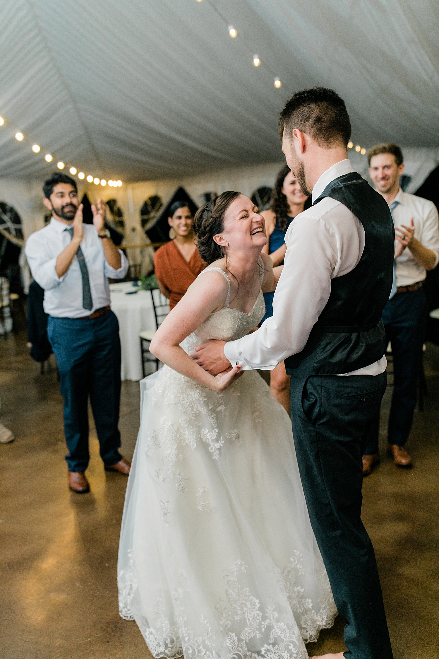 newlyweds laughing together on the dance floor by Baltimore wedding photographer