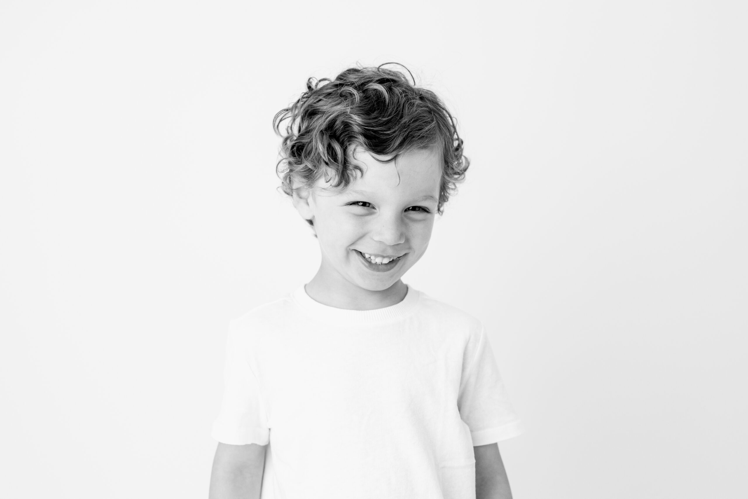 Curly haired boy smiling child photographer Baltimore studio portrait
