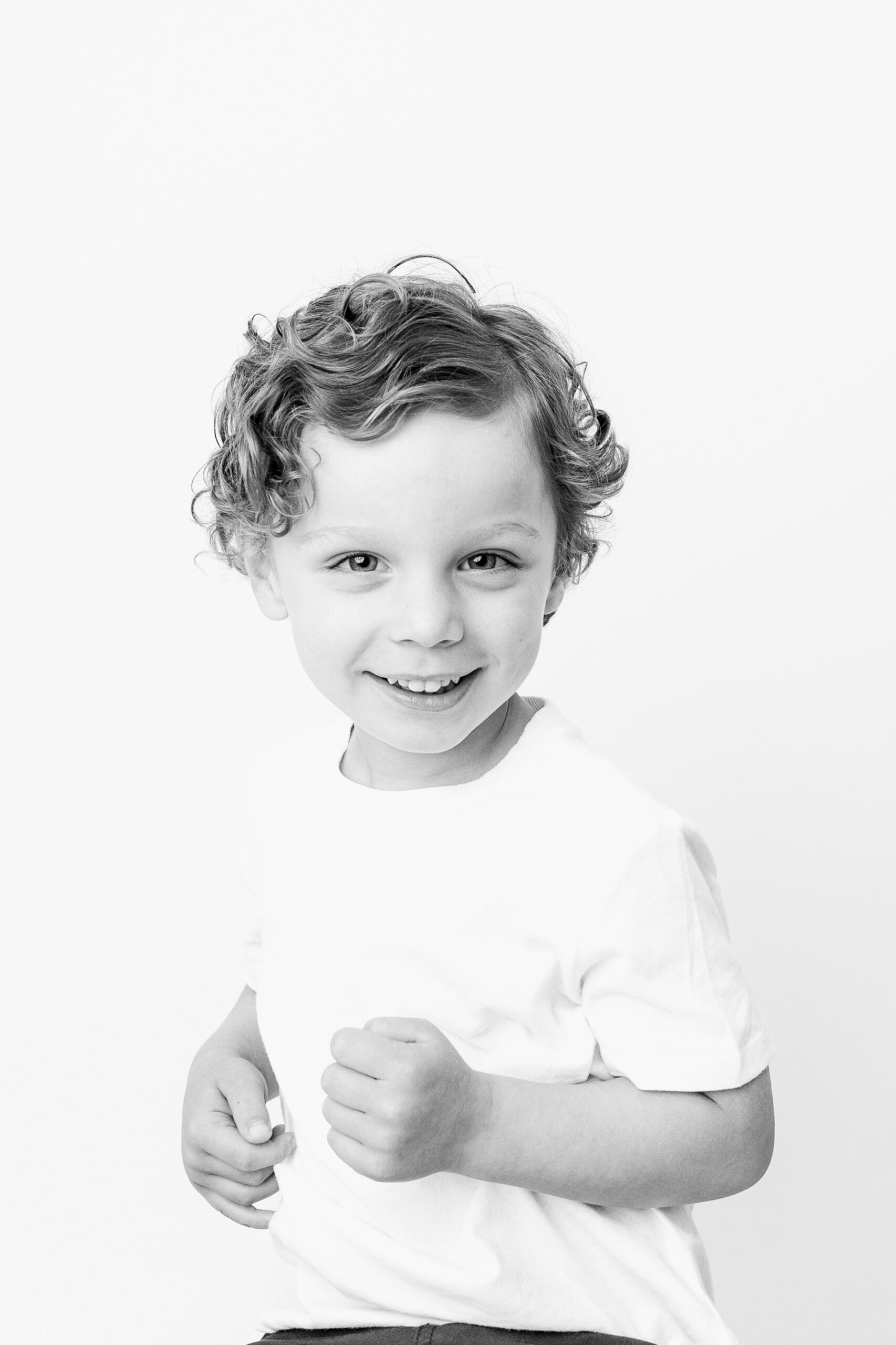 Curly haired boy smiling child photographer Baltimore studio portrait