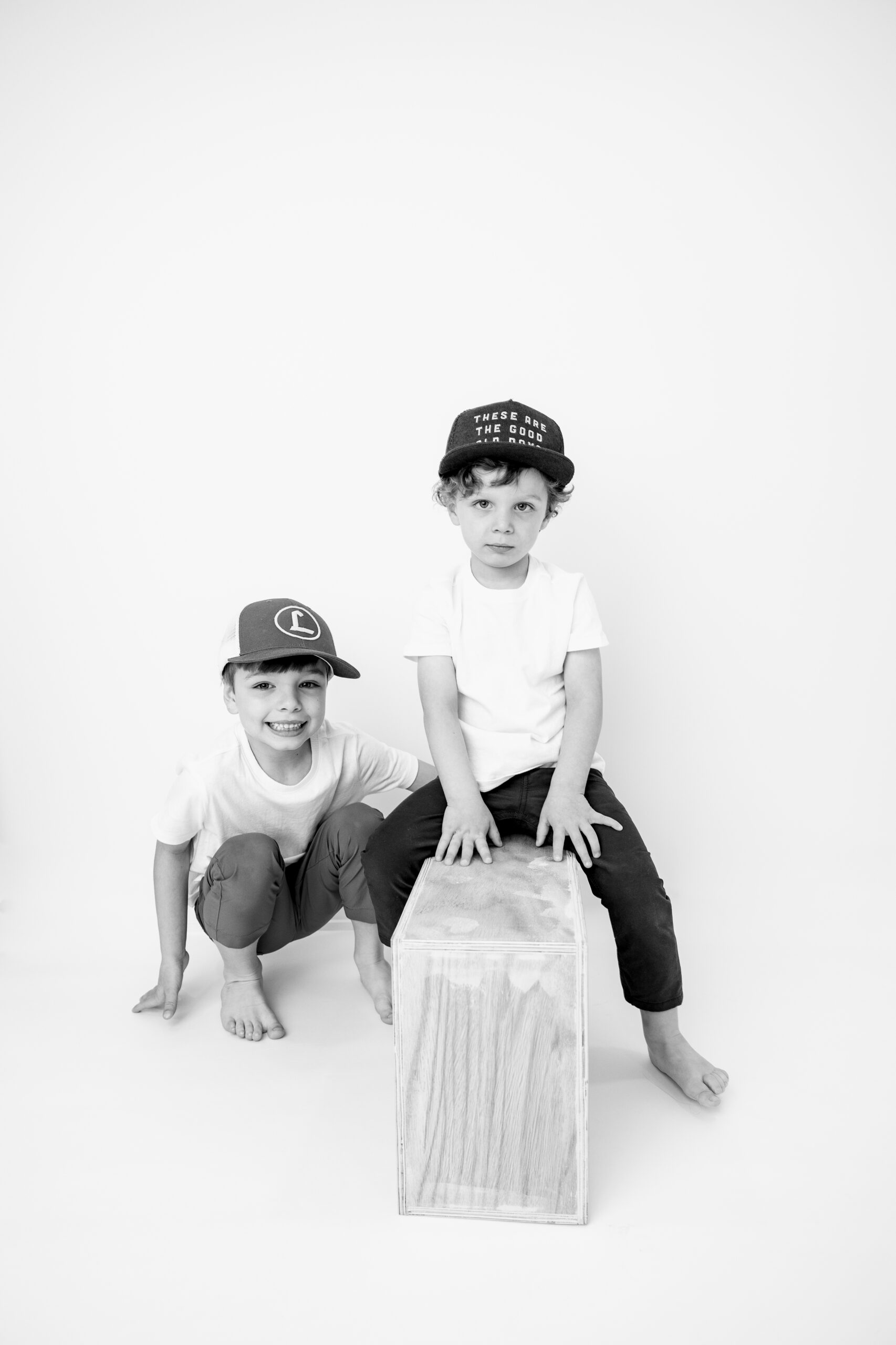 Black and white image of two young brothers in hats