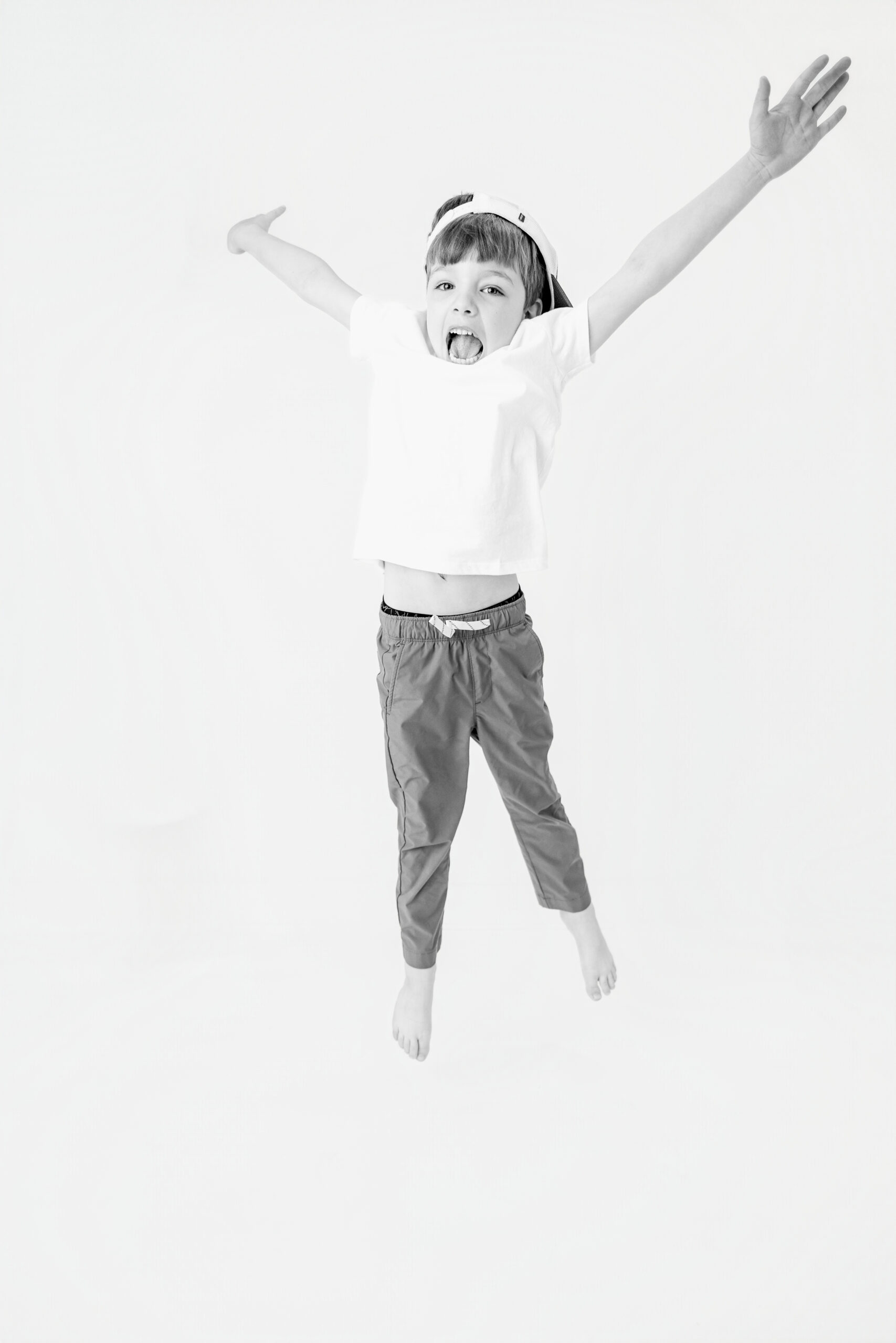 Energetic child jumping mid air with arms outstretched, child photographer Baltimore image