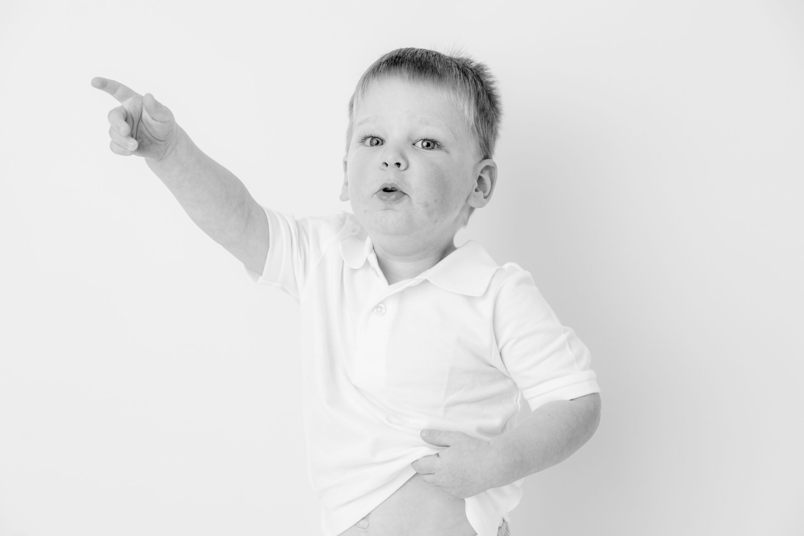 Baltimore children's photographer portrait of a toddler boy pointing with his arm stretched overhead