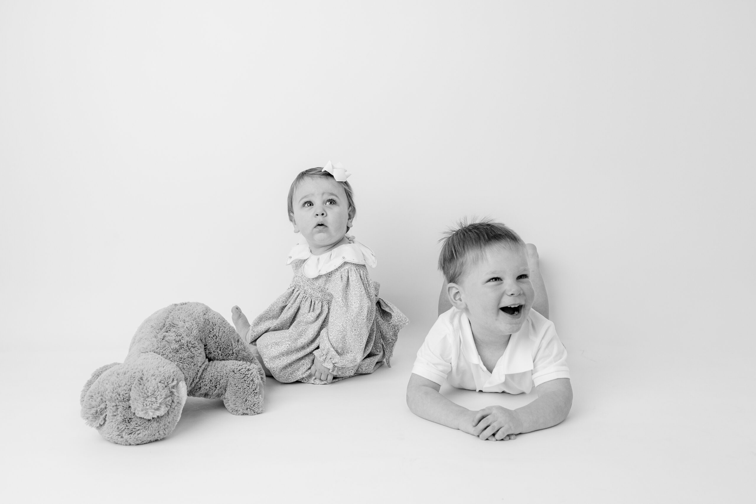 Two siblings sitting with a stuffed bunny toy, child photographer Baltimore session