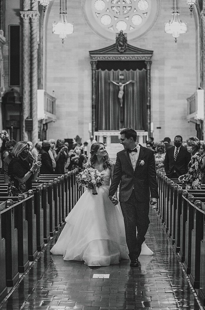 and bride and groom walking down the aisle of a church