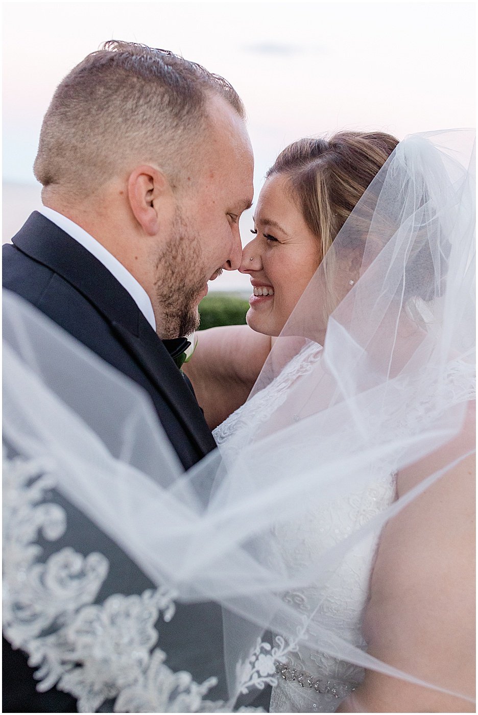 bride and groom hugging each other during sunset portraits at maryland waterfront wedding