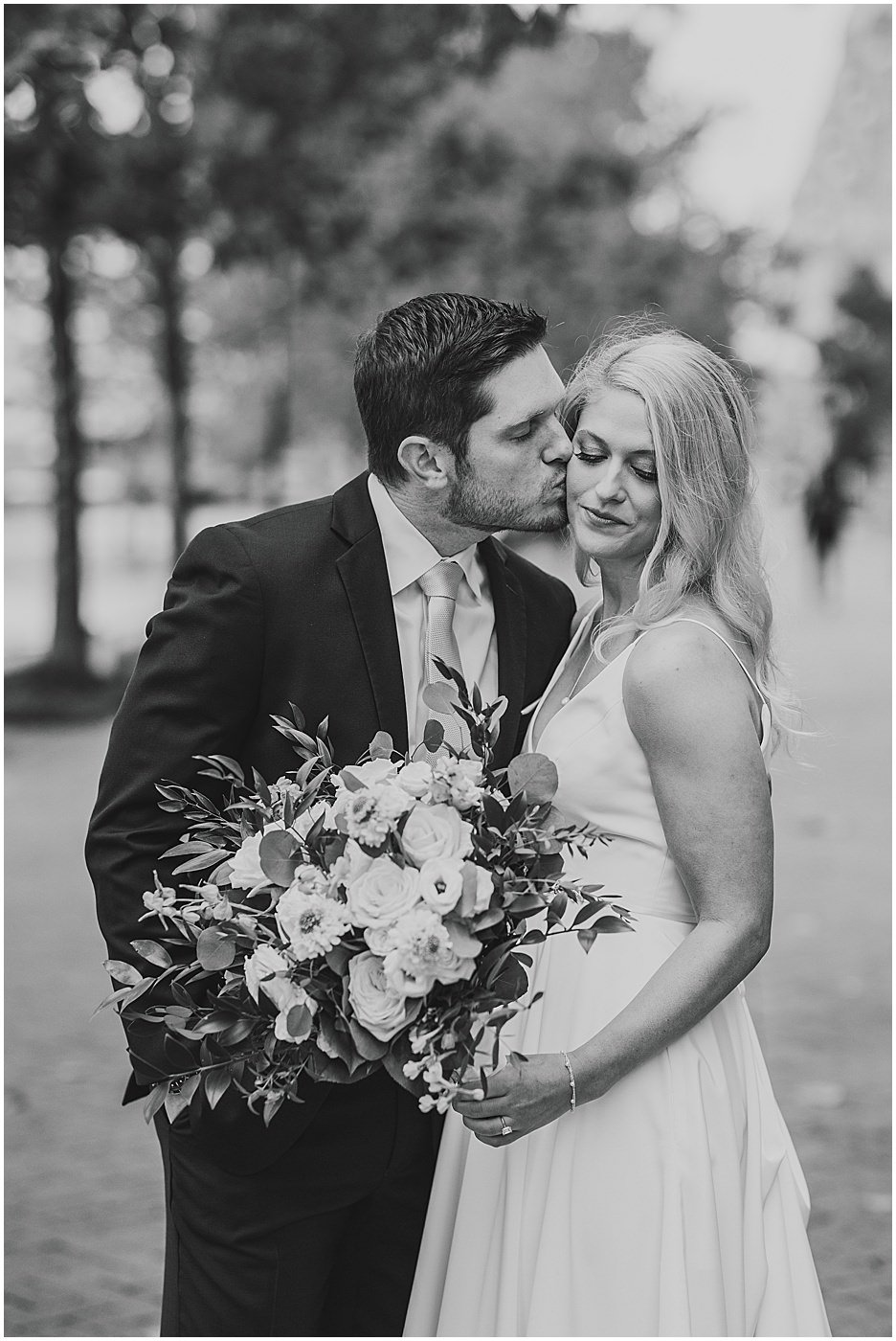 groom kissing bride during portraits balitmore md